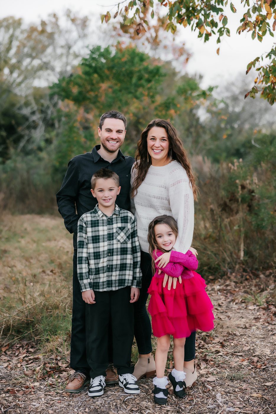 Family of four in an open field in autumn
