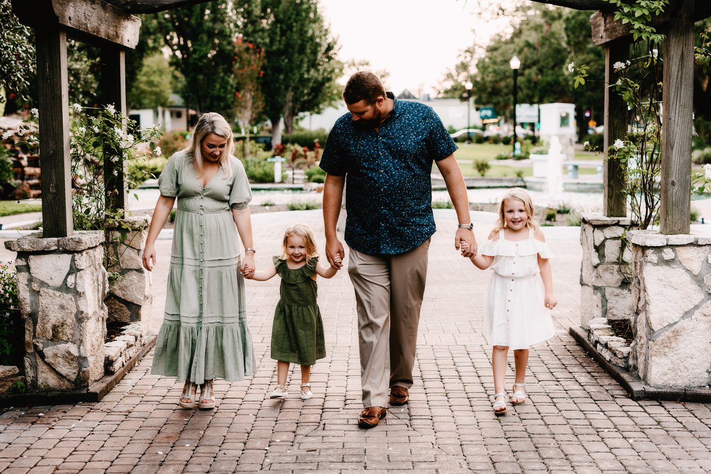 Family of four walking a brick path at golden hour