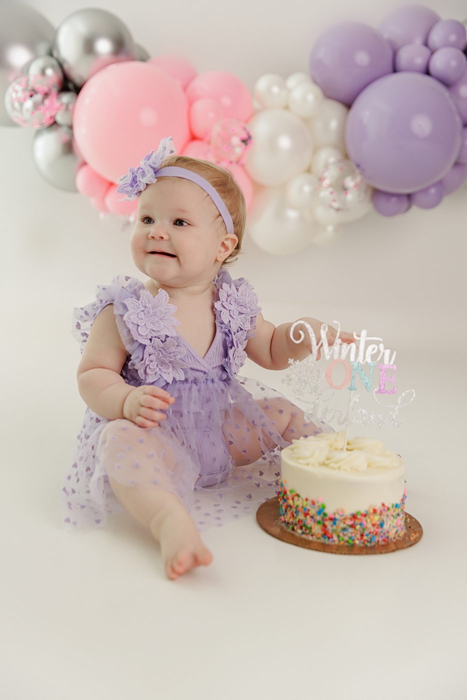 Cake smash session with a pastel balloon garland