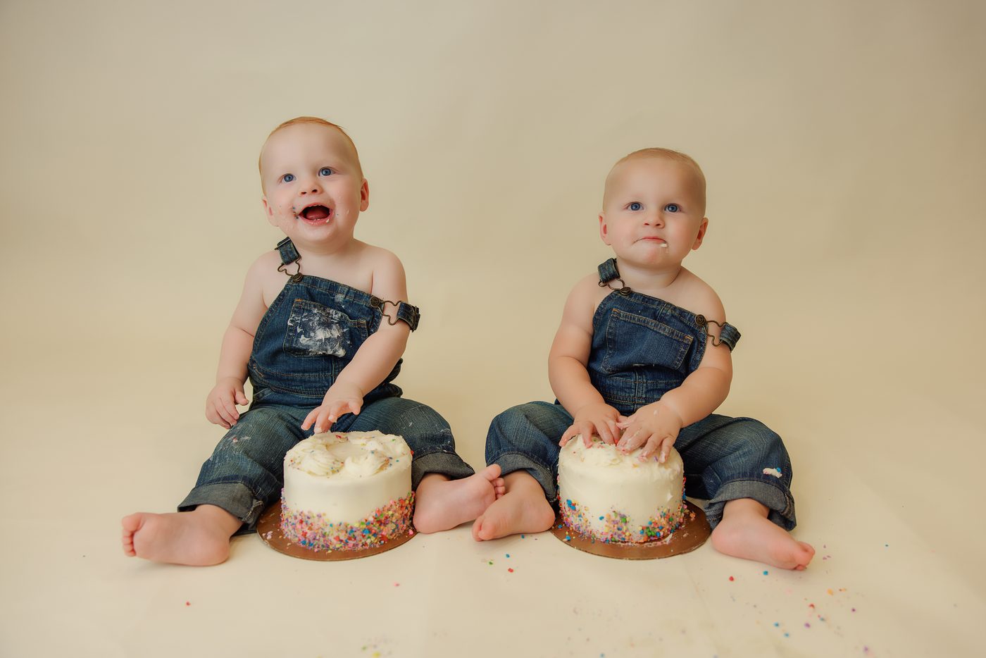 Twin brothers at their first birthday cake smash
