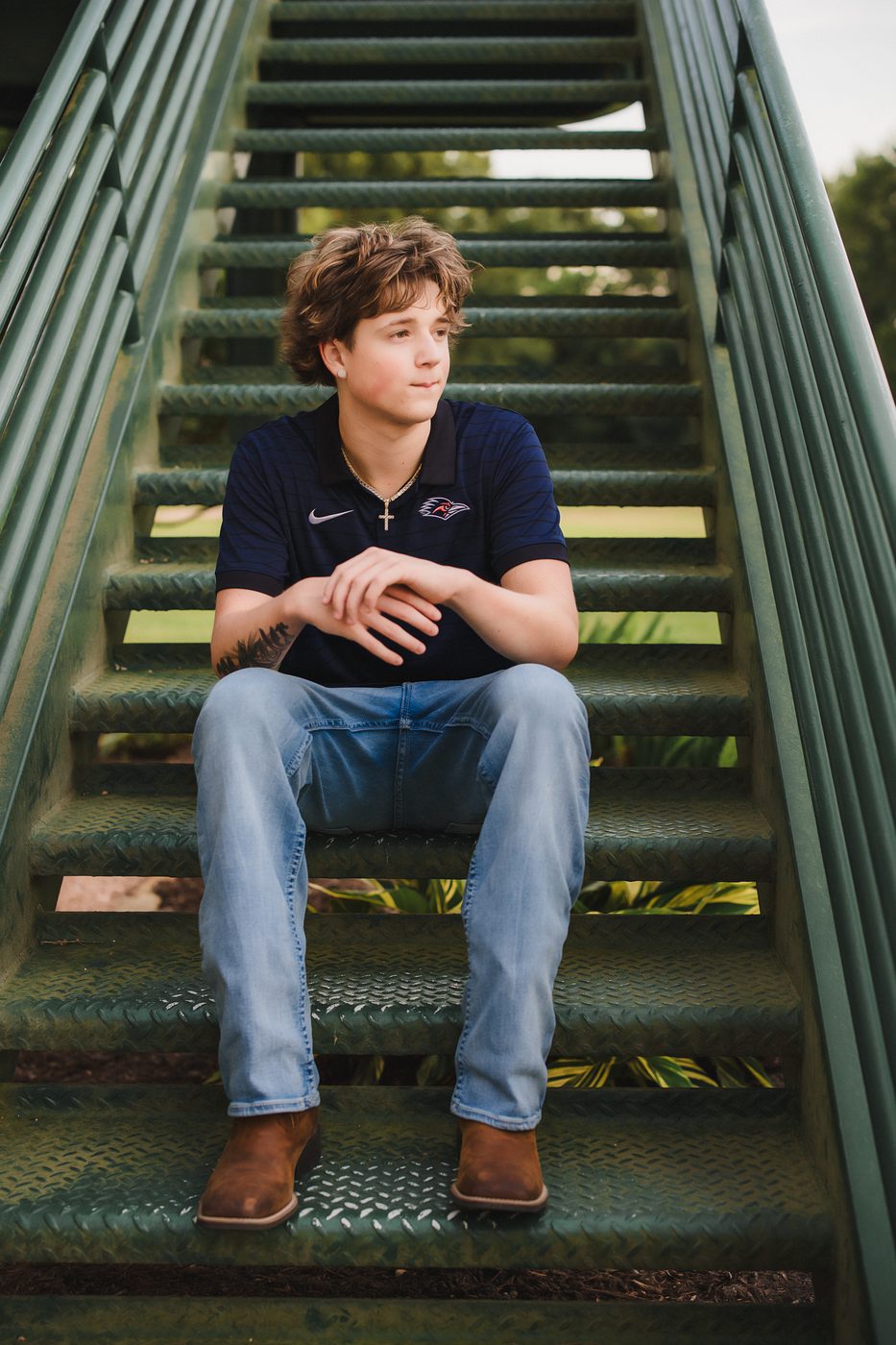 Senior boy seated on a steel staircase