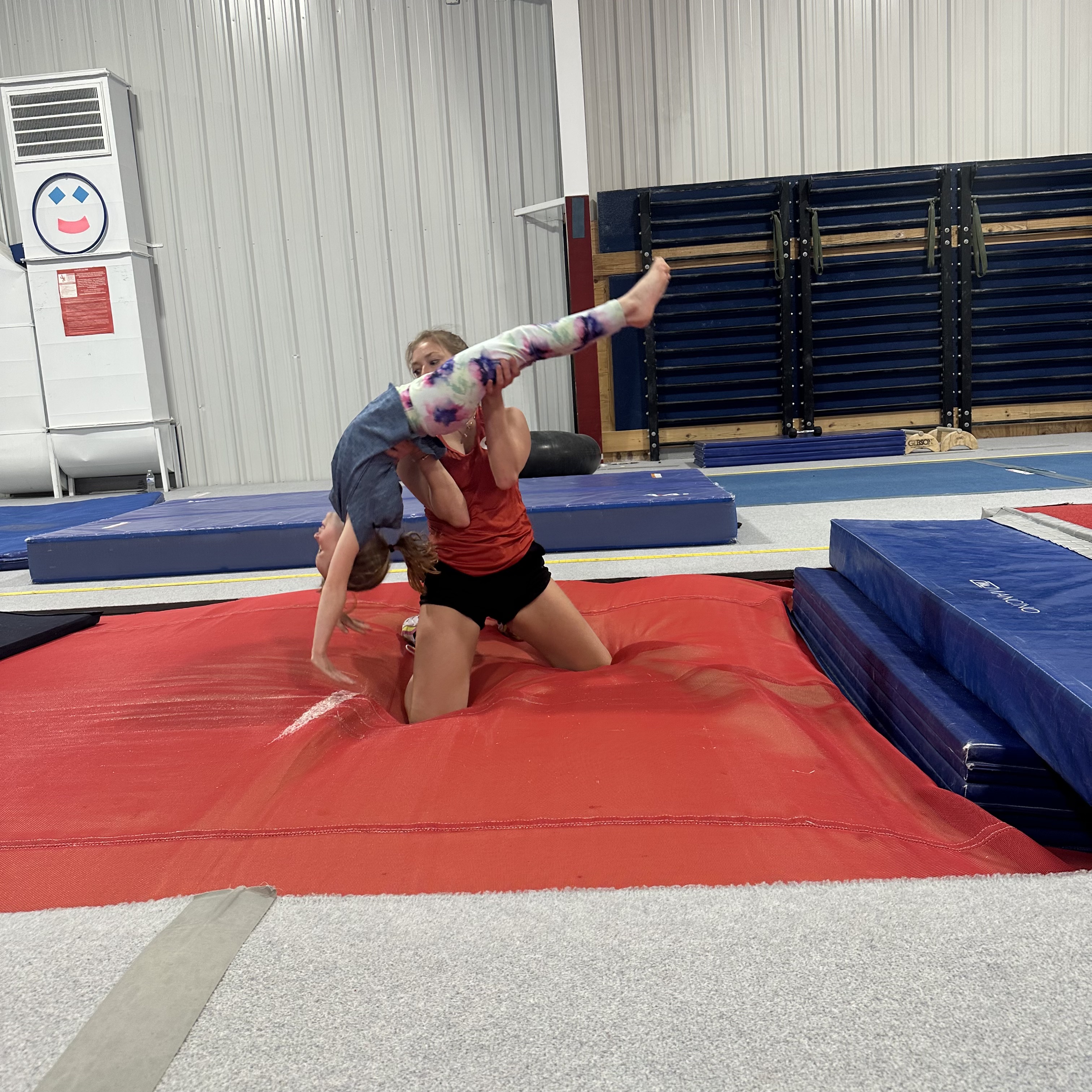 Coach spotting a young gymnast 
