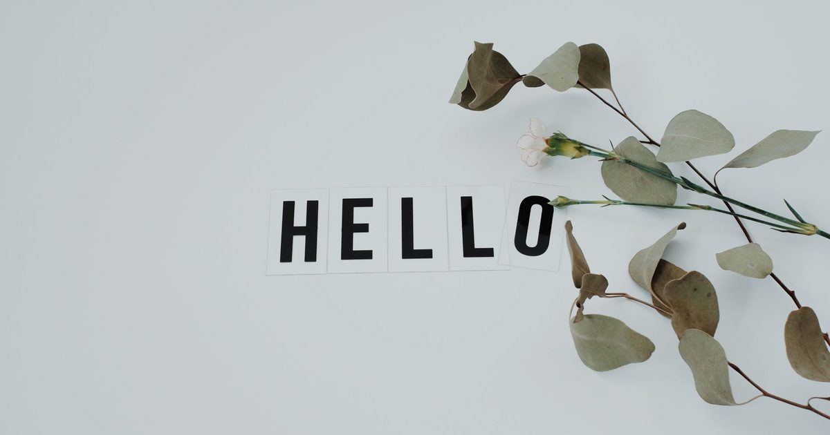 The word HELLO spelled in letter tiles beside a eucalyptus sprig