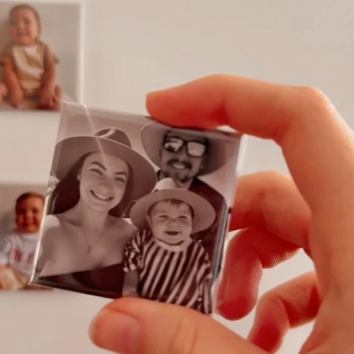 En fotomagnet med ett familjeporträtt hålls i handen