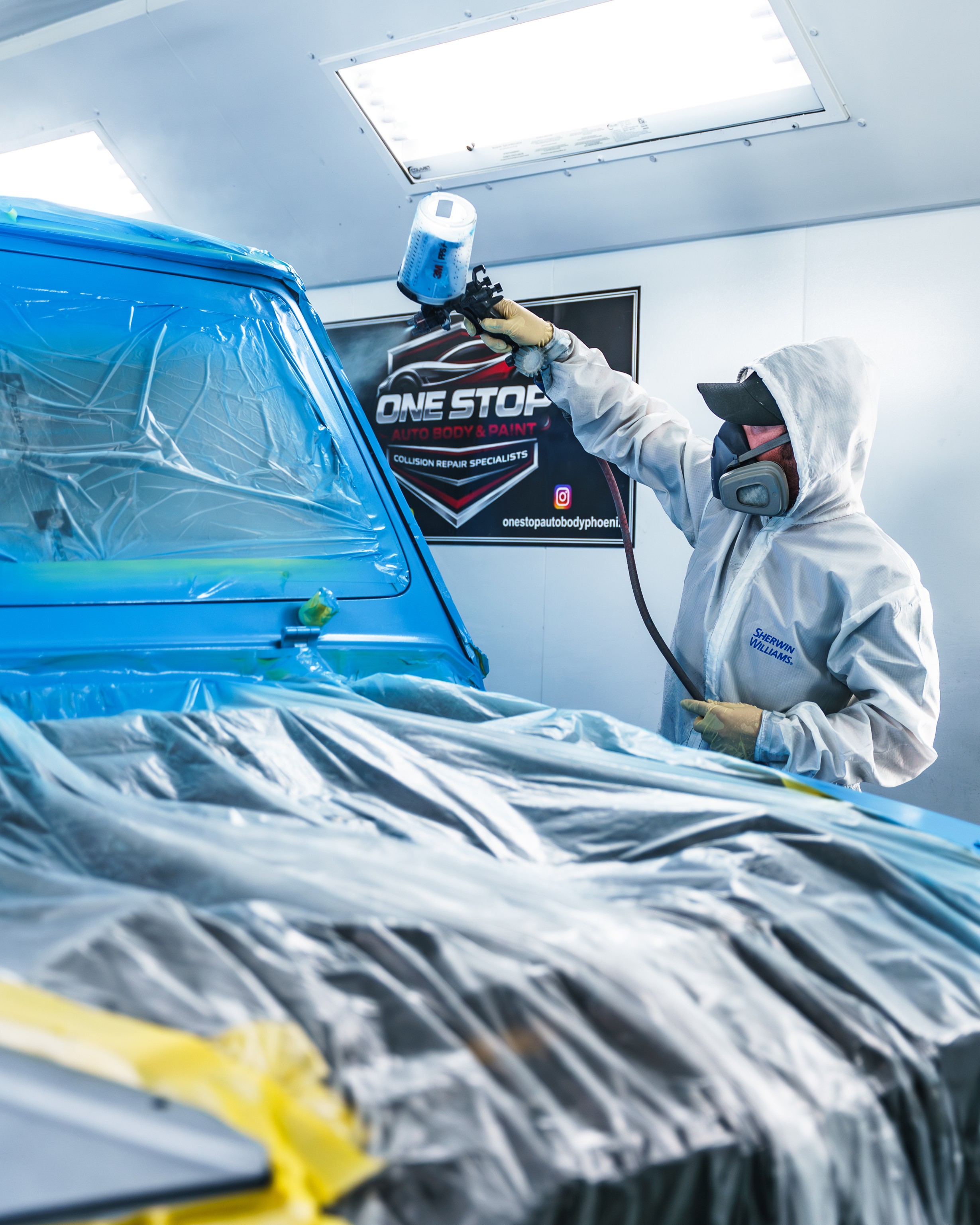 Team member painting a car after collision repair