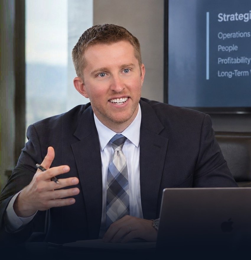 Alex Kirk, business acquisition coach, at a boardroom table