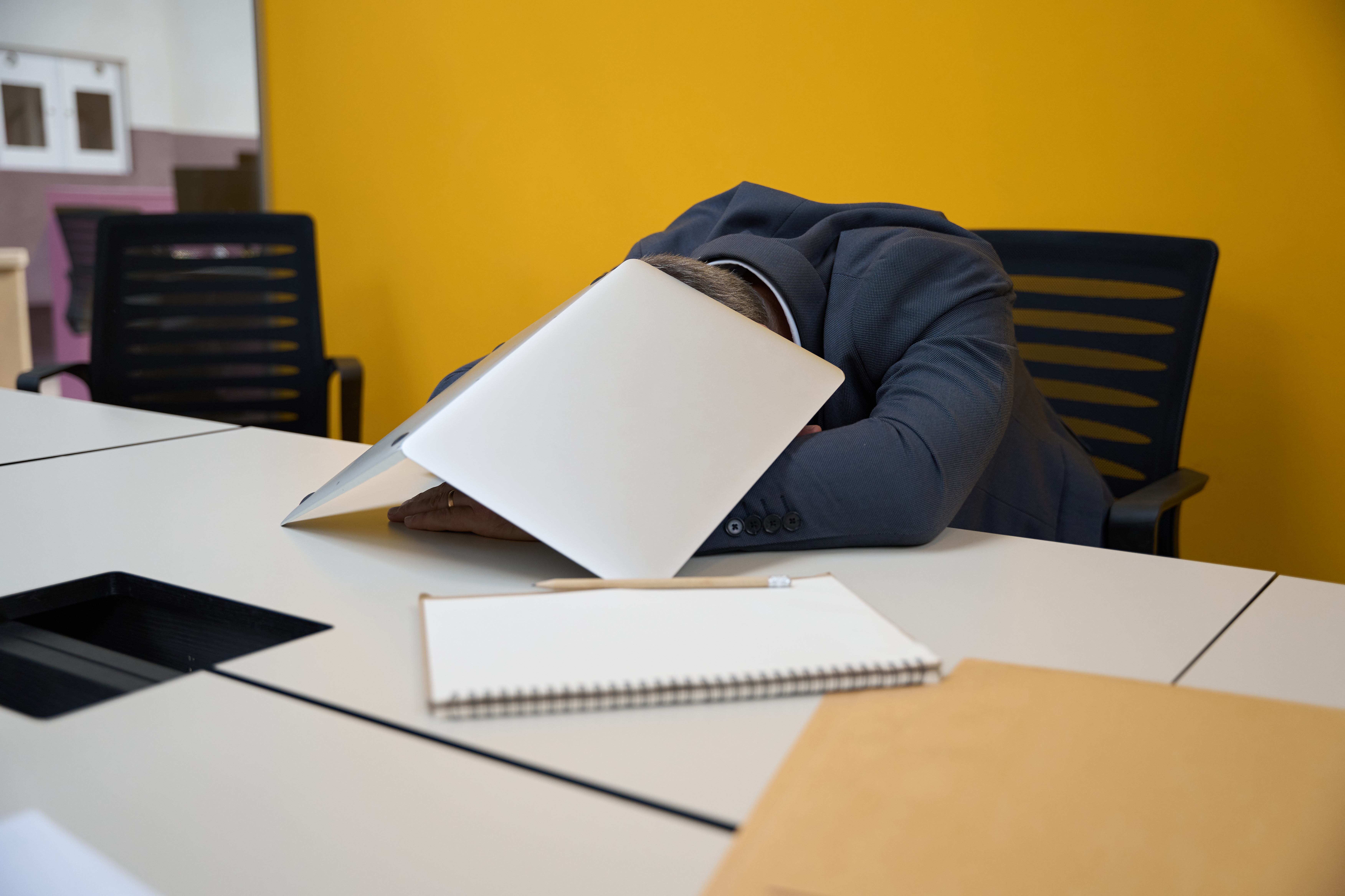 Exhausted person at desk representing burnout and nervous system dysregulation