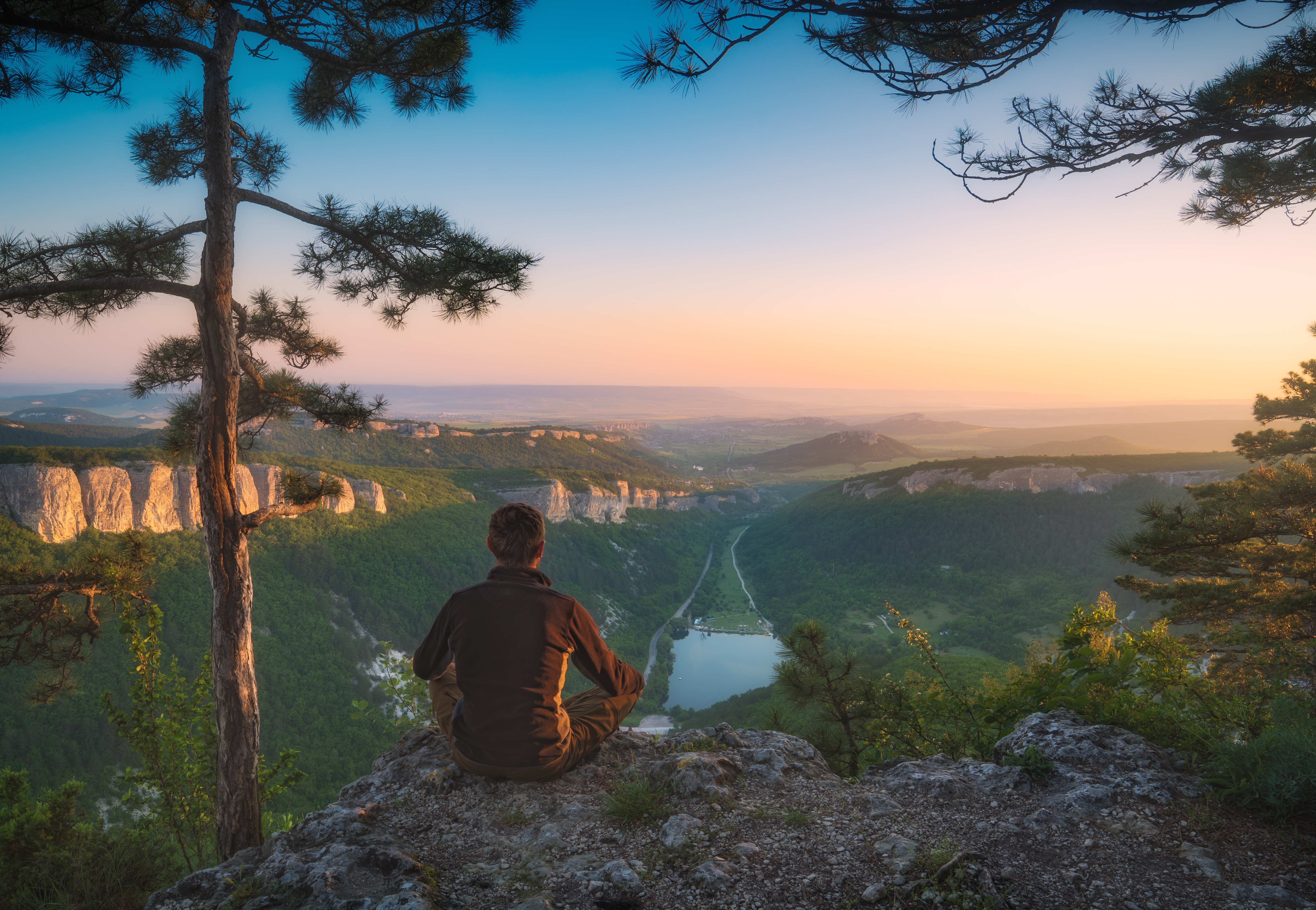 Person sitting calmly in nature representing nervous system regulation and inner peace