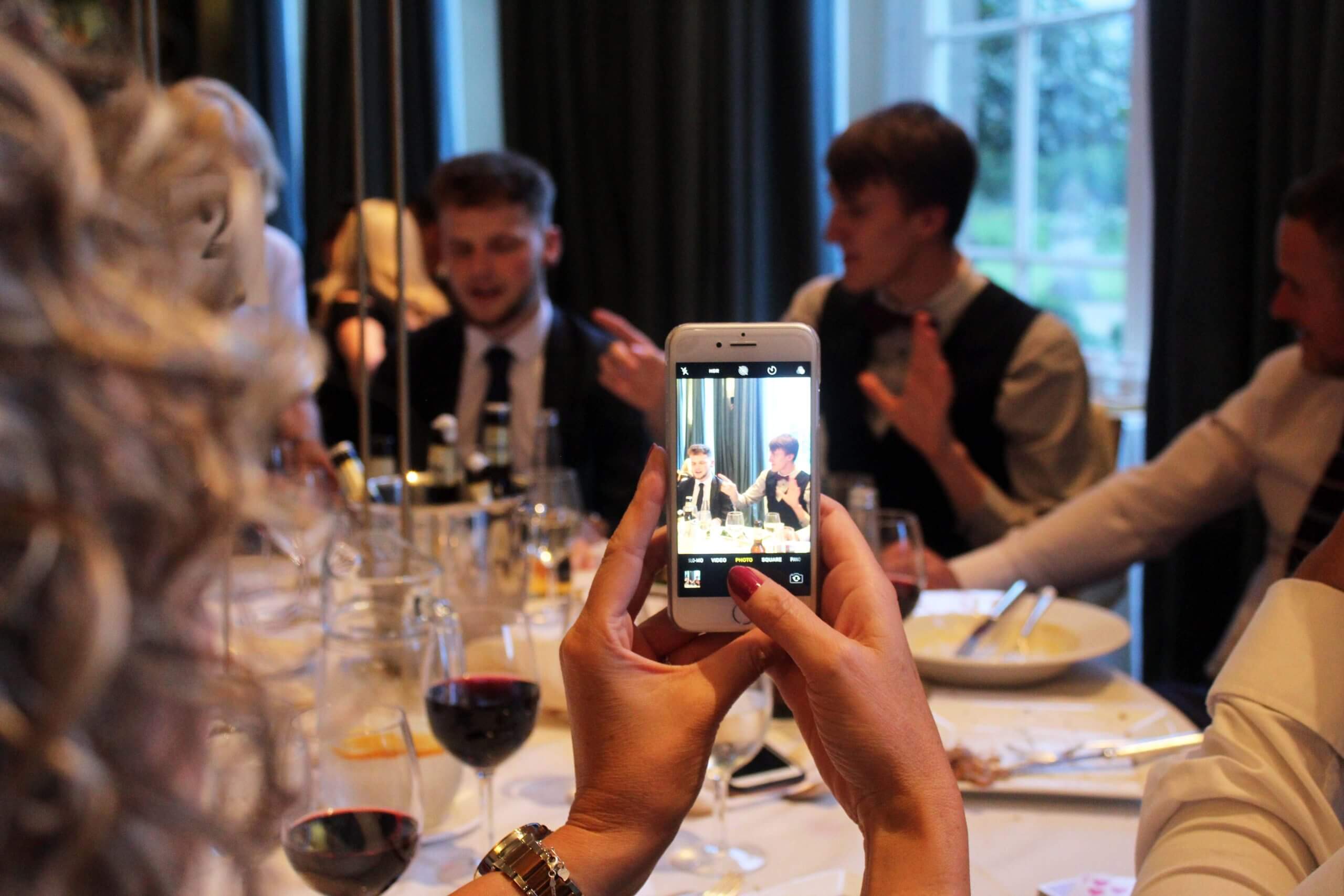 Guests watching close-up magic at a table during an event