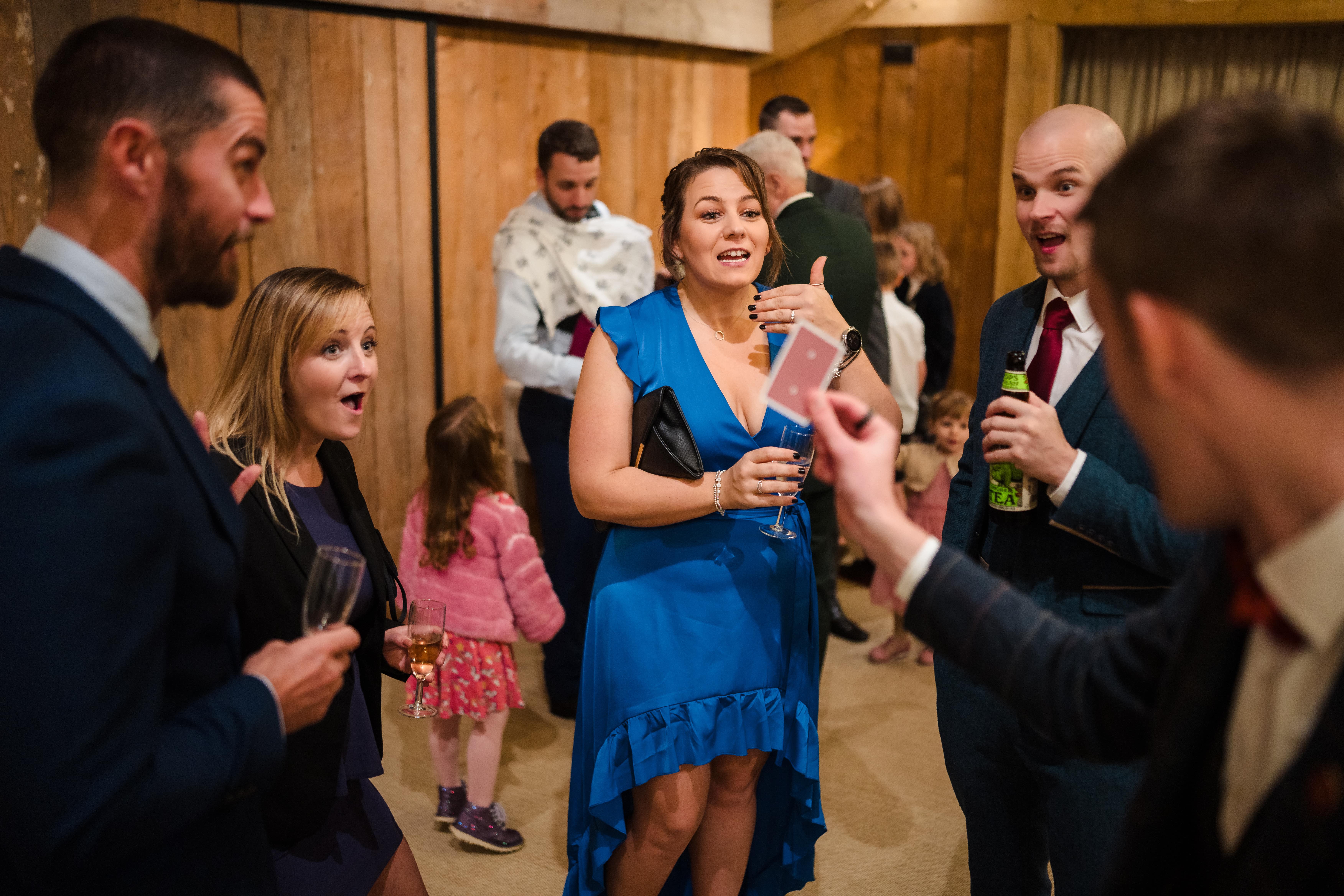 Wedding guests enjoying close-up magic during the d receptioninks
