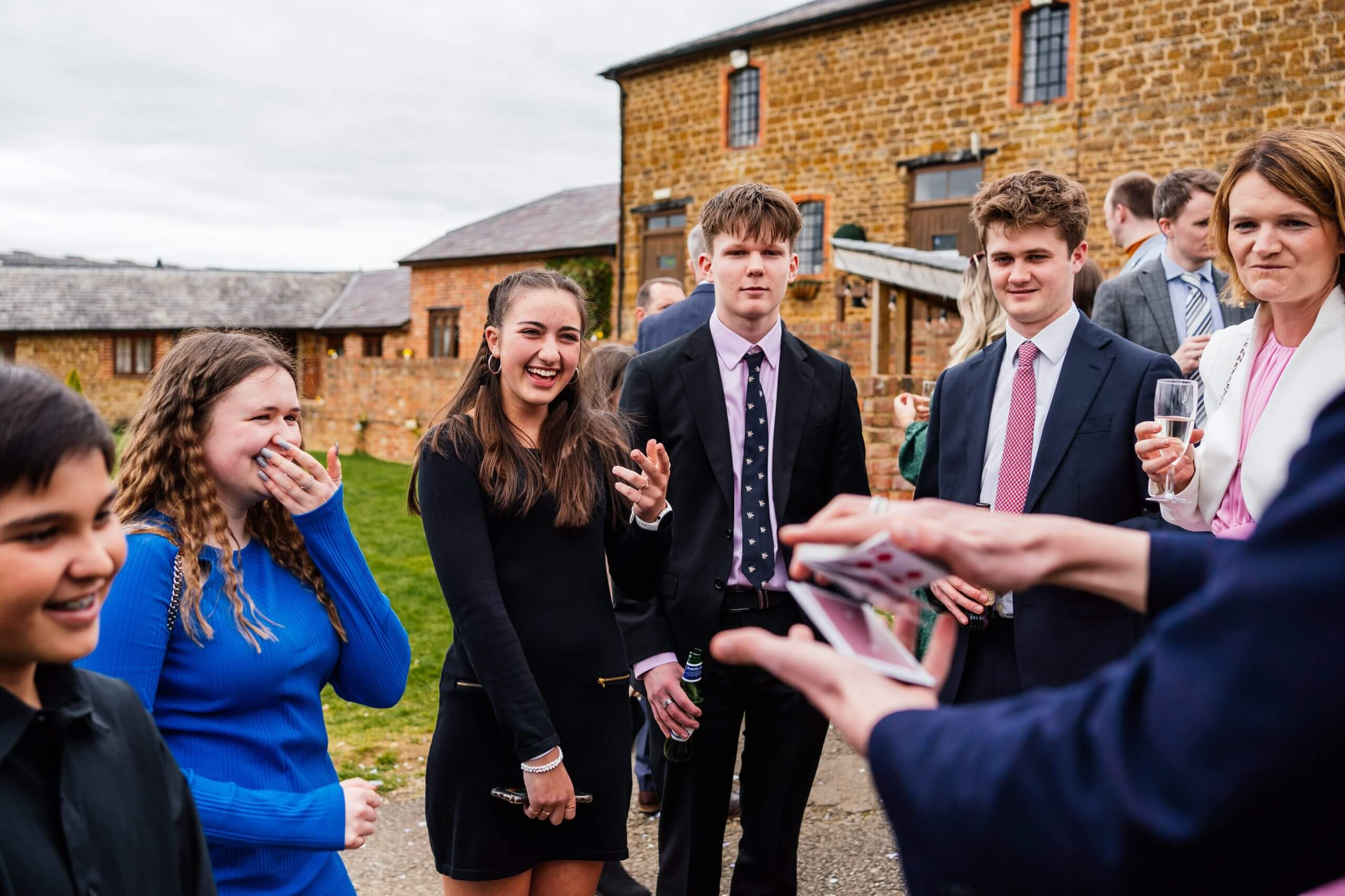 Guests of all ages enjoying close-up magic at a private celebration