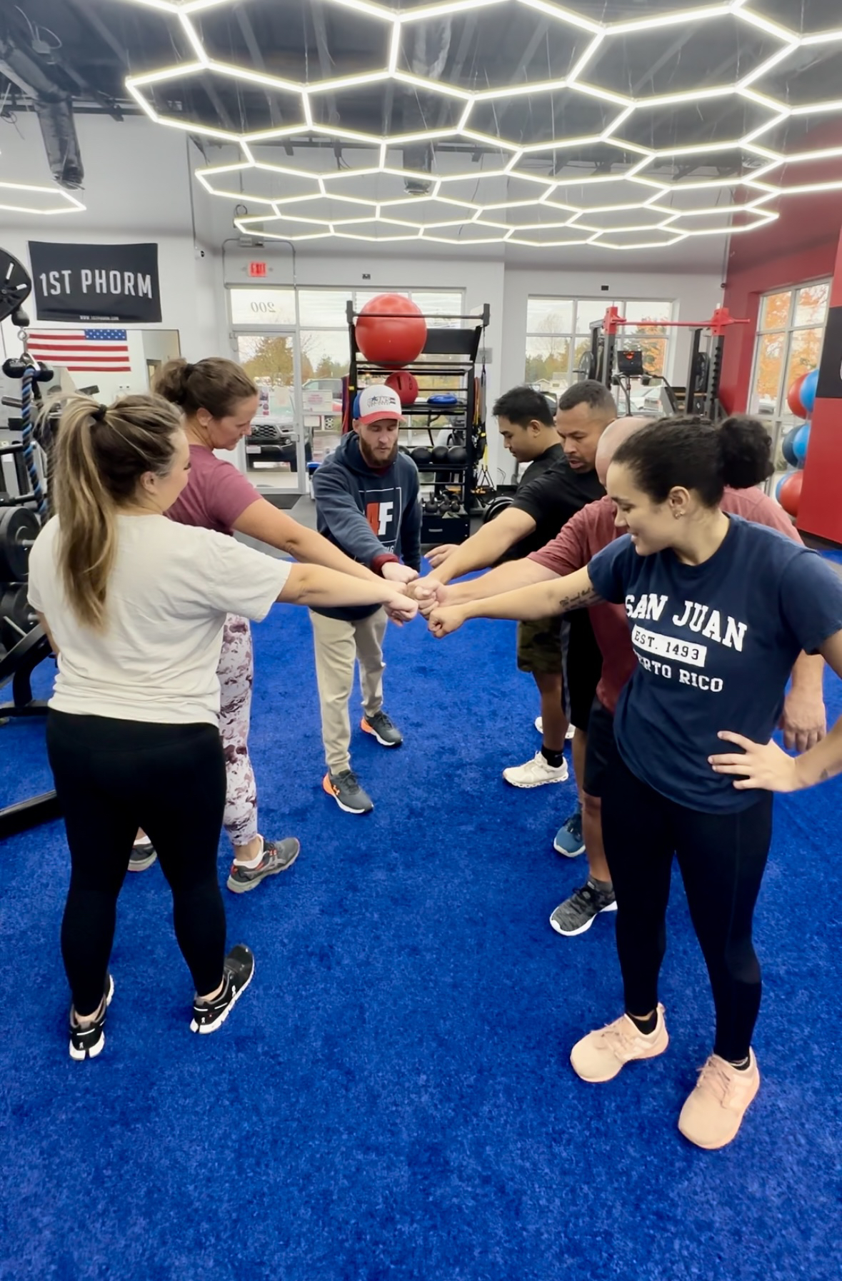 4F Coaching members putting their fists in the middle — Go Fam!