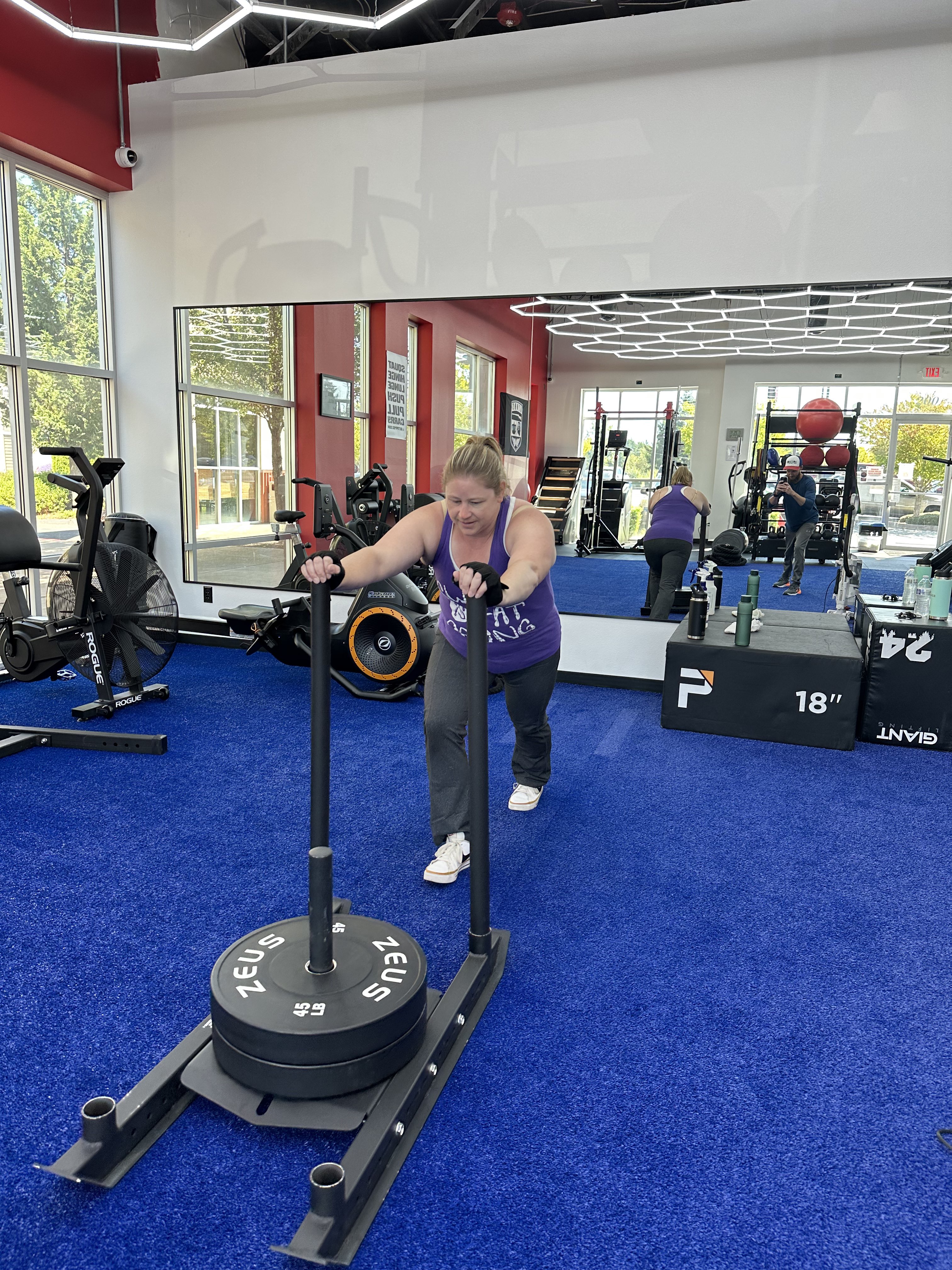 A 4F member pushing a weighted sled during training at 4F Coaching in Graham, WA