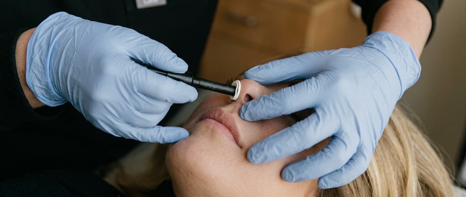 A practitioner performing a bilateral nasal specific insufflation