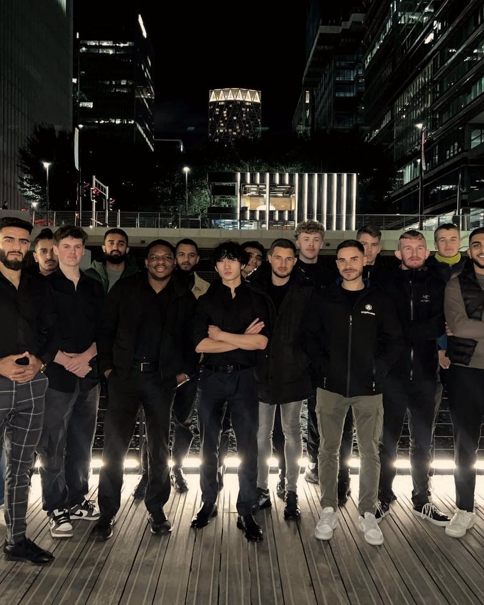 A group of attendees on a city waterfront at night