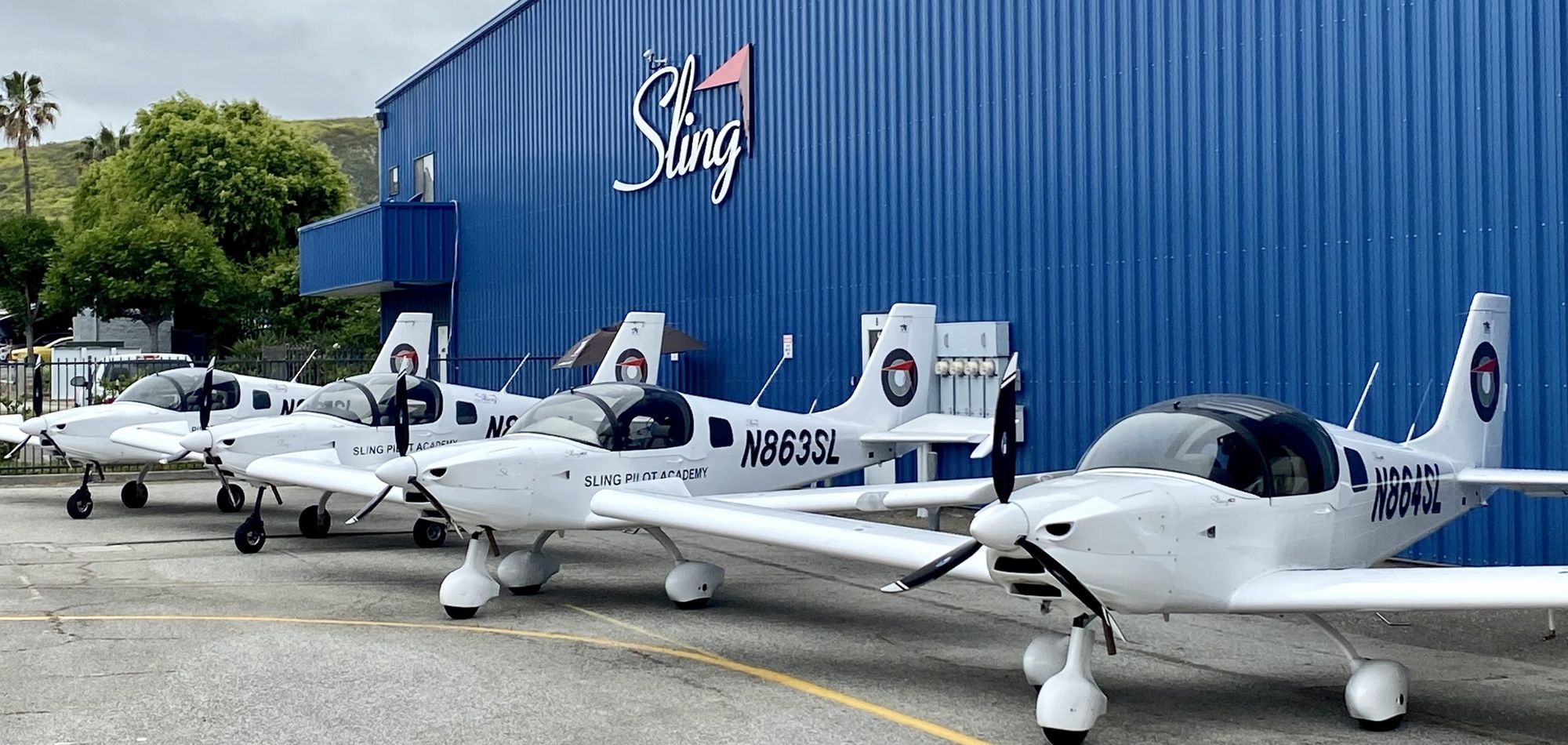 Sling training aircraft lined up outside the hangar