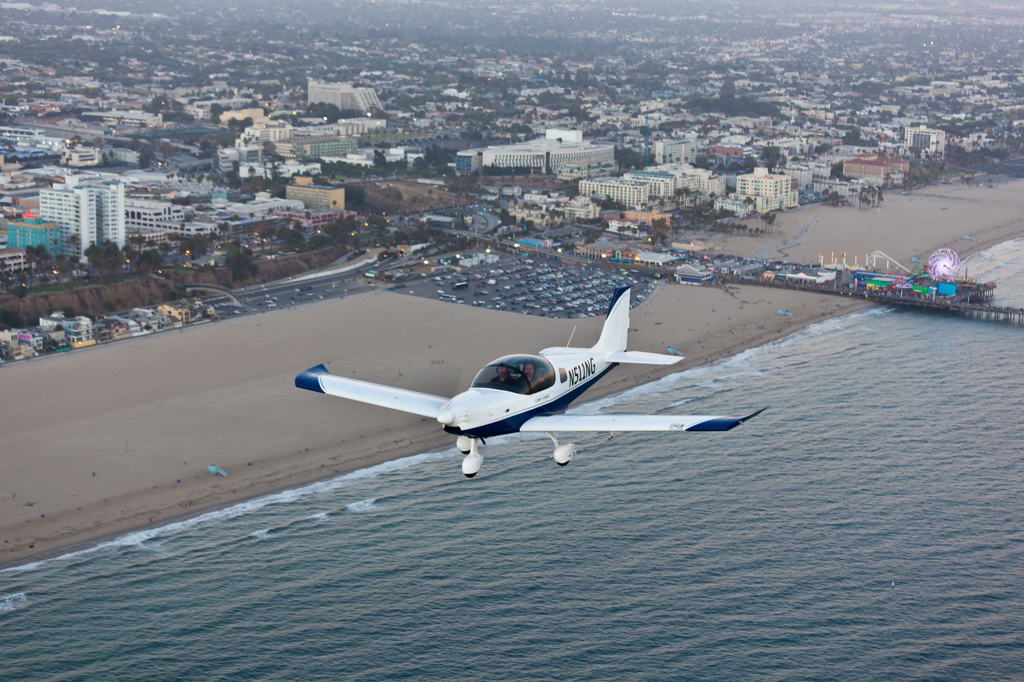 A Sling aircraft flying over the Santa Monica Pier