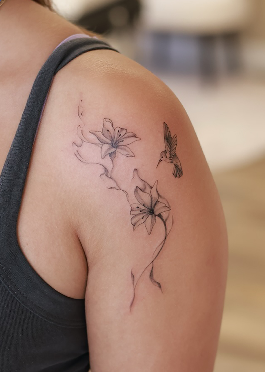 Tatouage floral fine line sur l’épaule