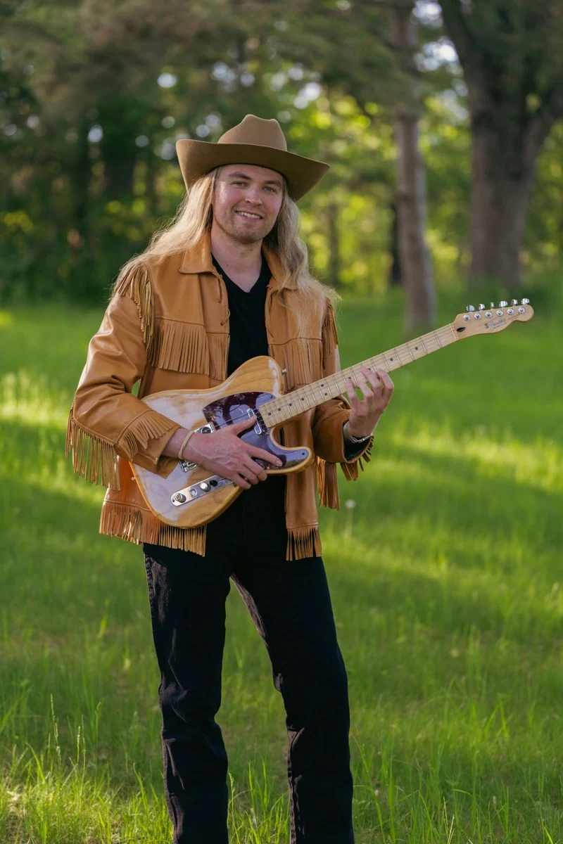 Ethan Elseth outdoors with his electric guitar