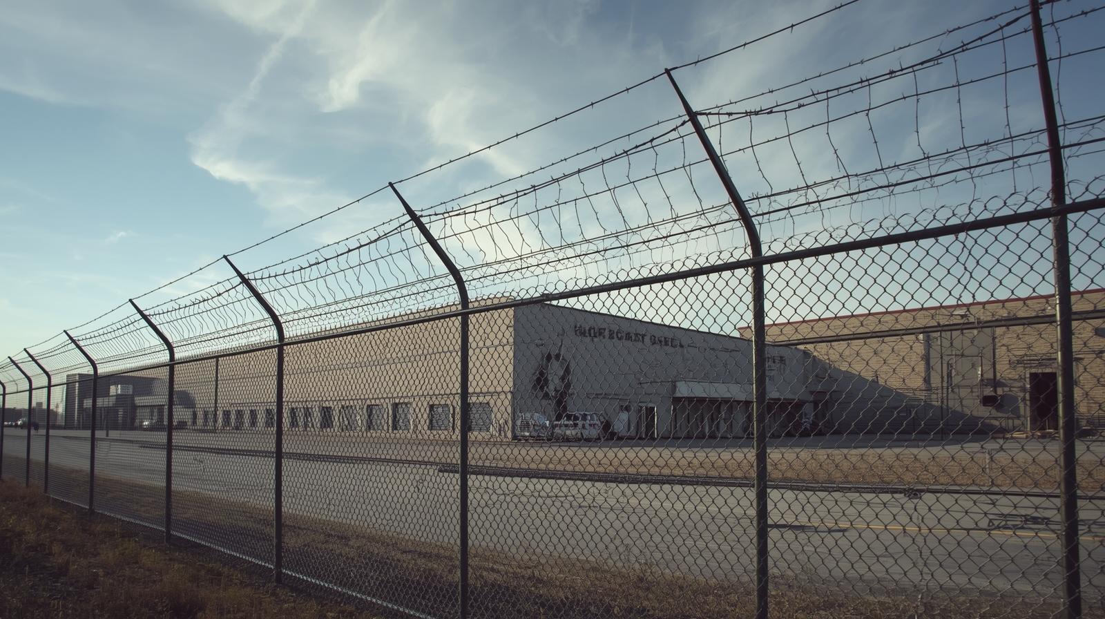Commercial warehouse security fence installation in Rockford IL with chain link and access gate. Commercial warehouse security fence installation in Rockford IL with chain link and access gate.