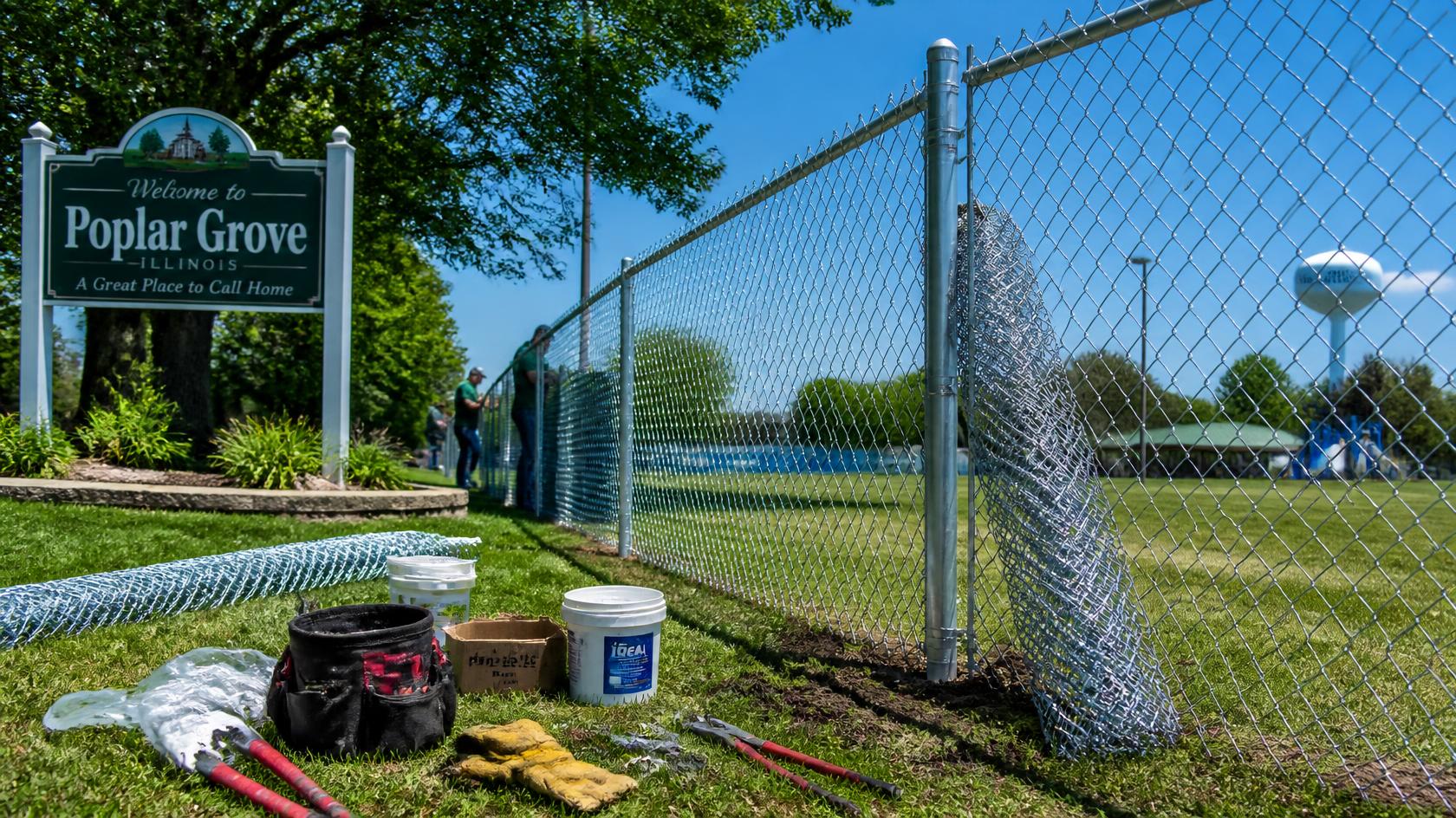 Chain link fence in Poplar Grove, IL being repaired to maintain a secure and well-defined yard.