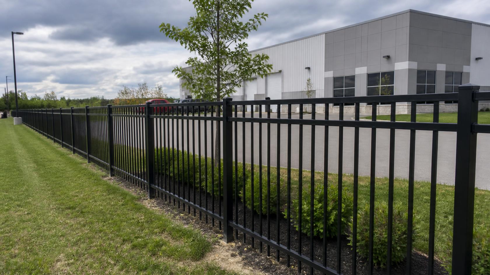Commercial fence in Davis Junction, IL being inspected and repaired for damaged sections that may affect property security.