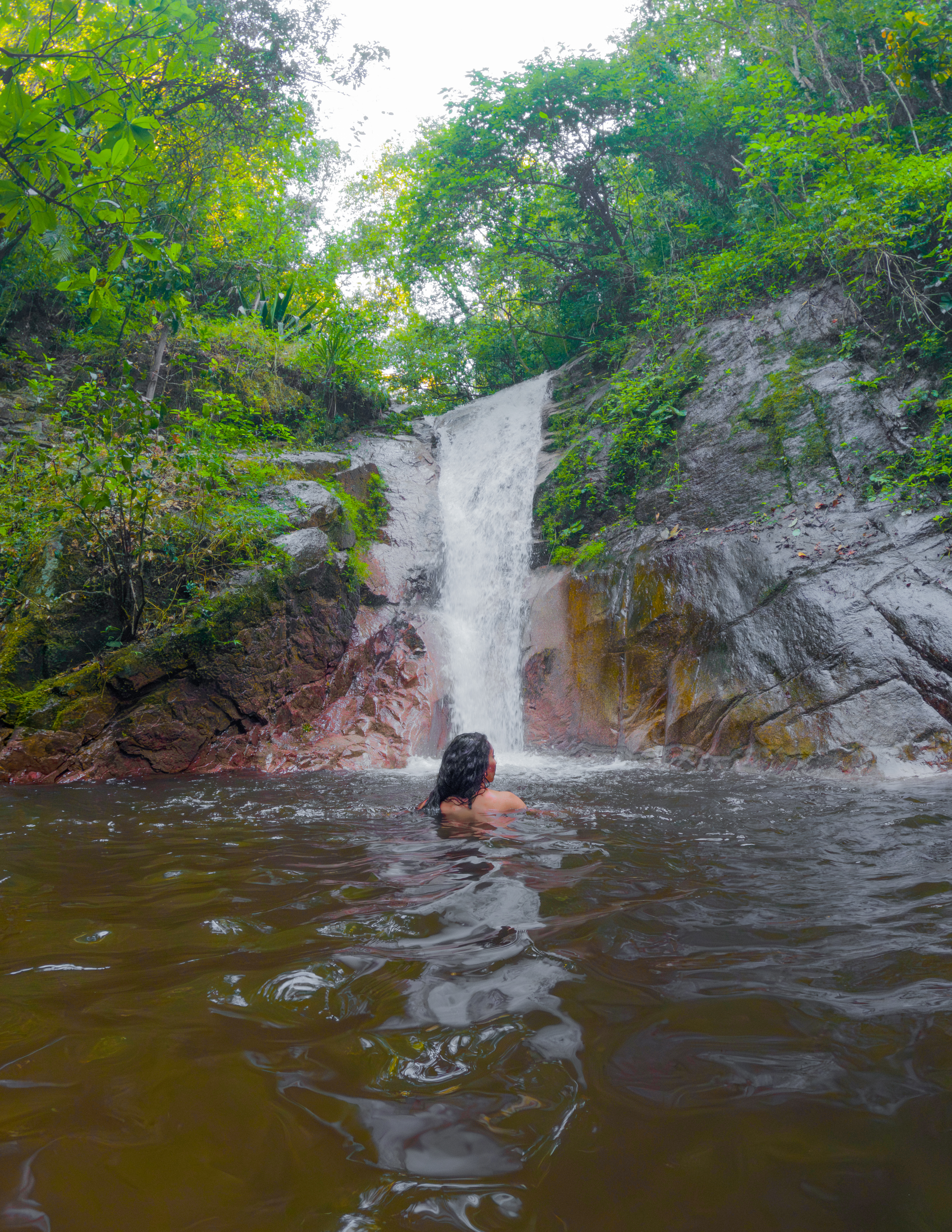 Guest enjoying a waterfall surrounded by tropical forest