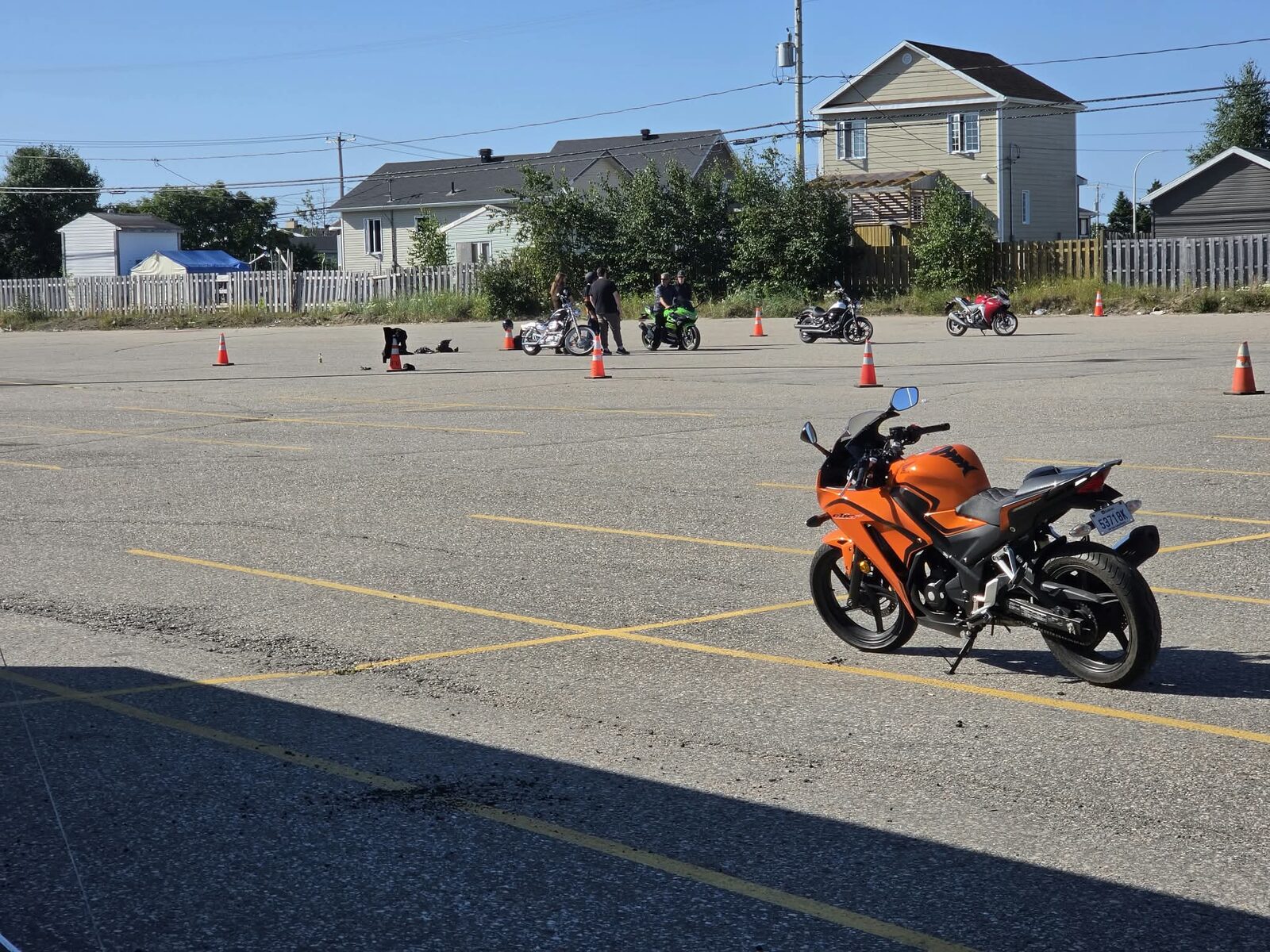 Deux élèves à moto entre les cônes sur le terrain d'entraînement
