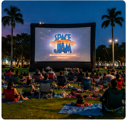 Families watching an outdoor movie under the stars at ArtsPark in Hollywood, Florida.