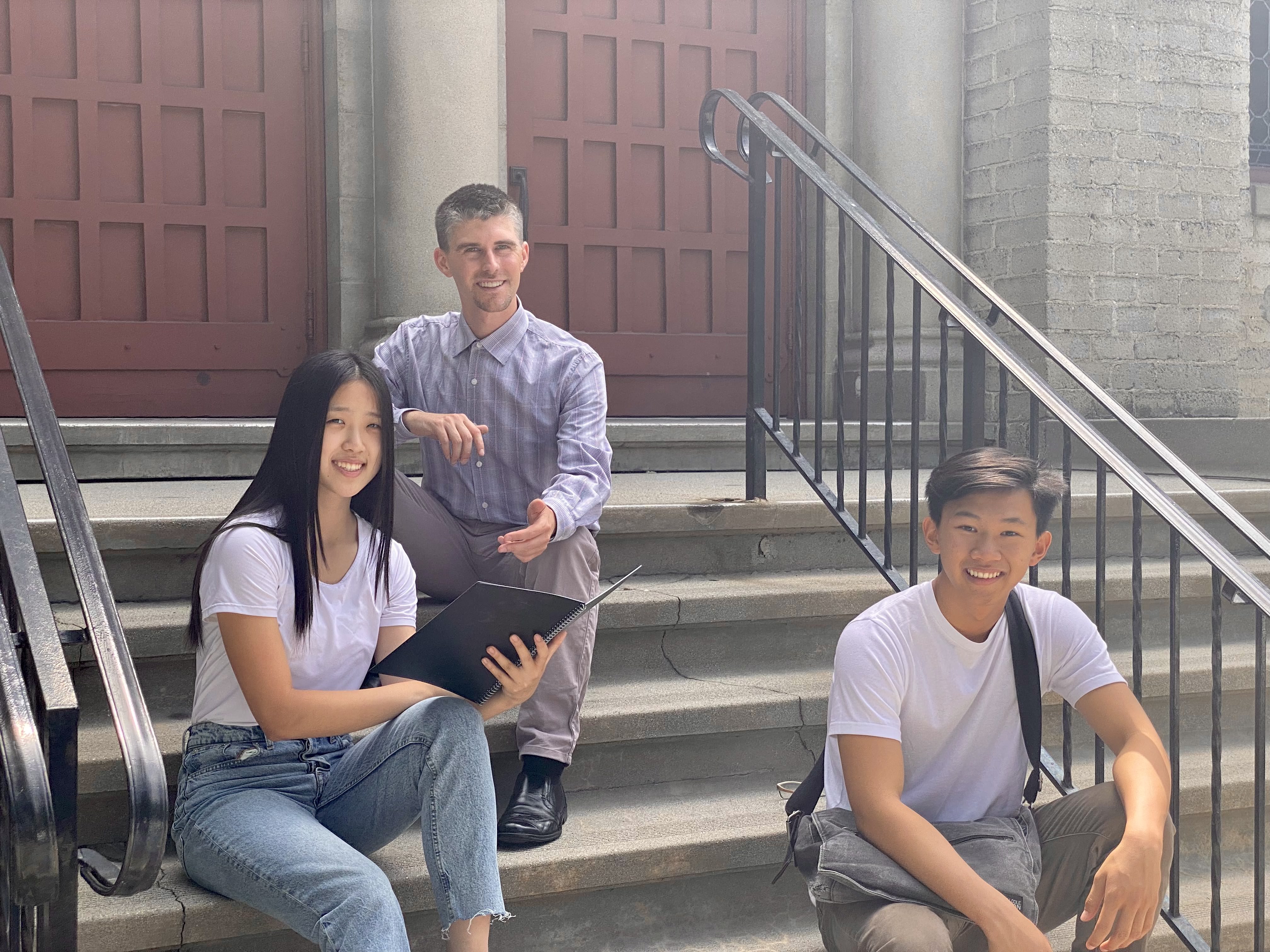 Robert with students on campus stairs