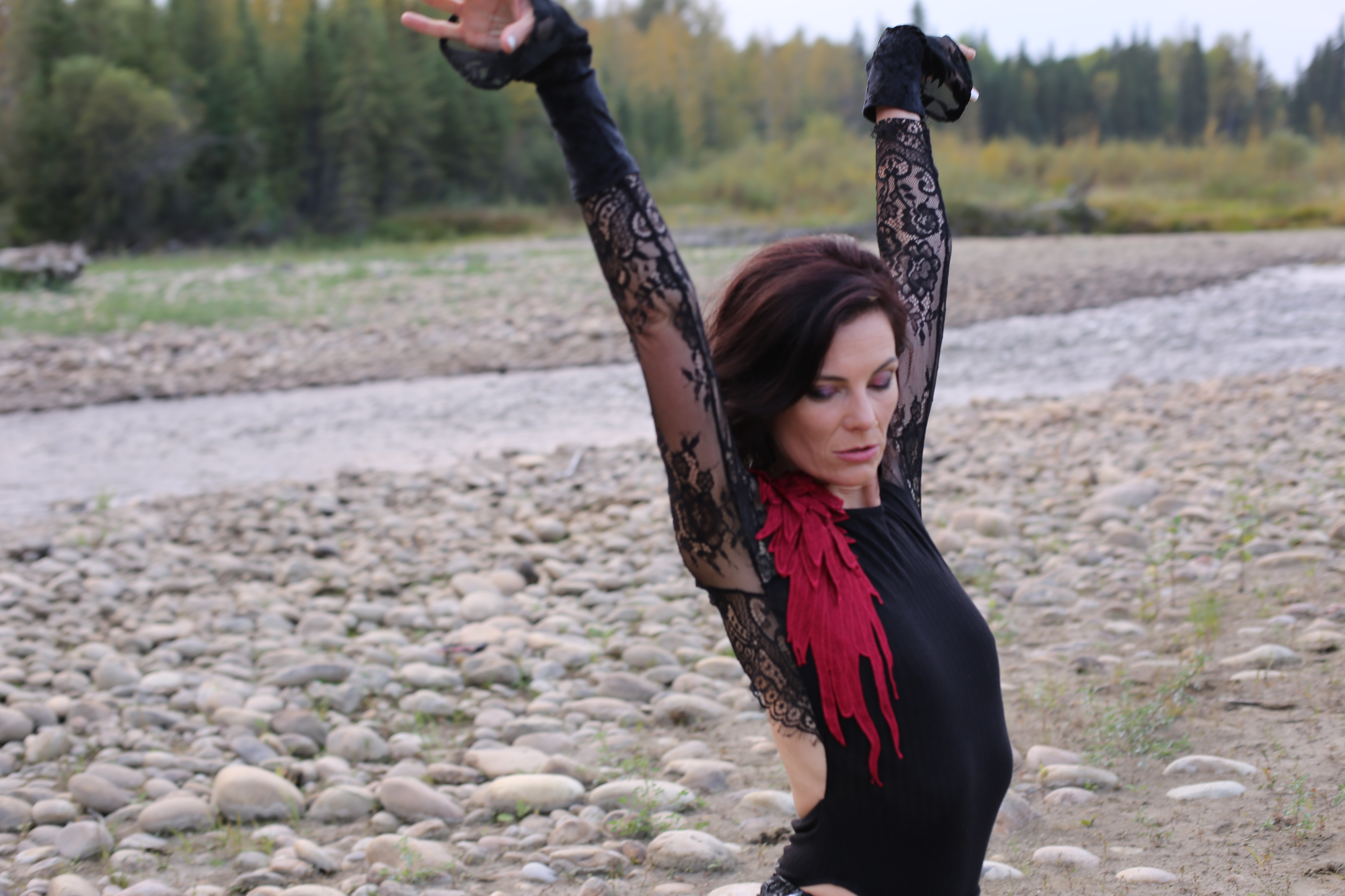 Arms raised on the riverbed in black lace