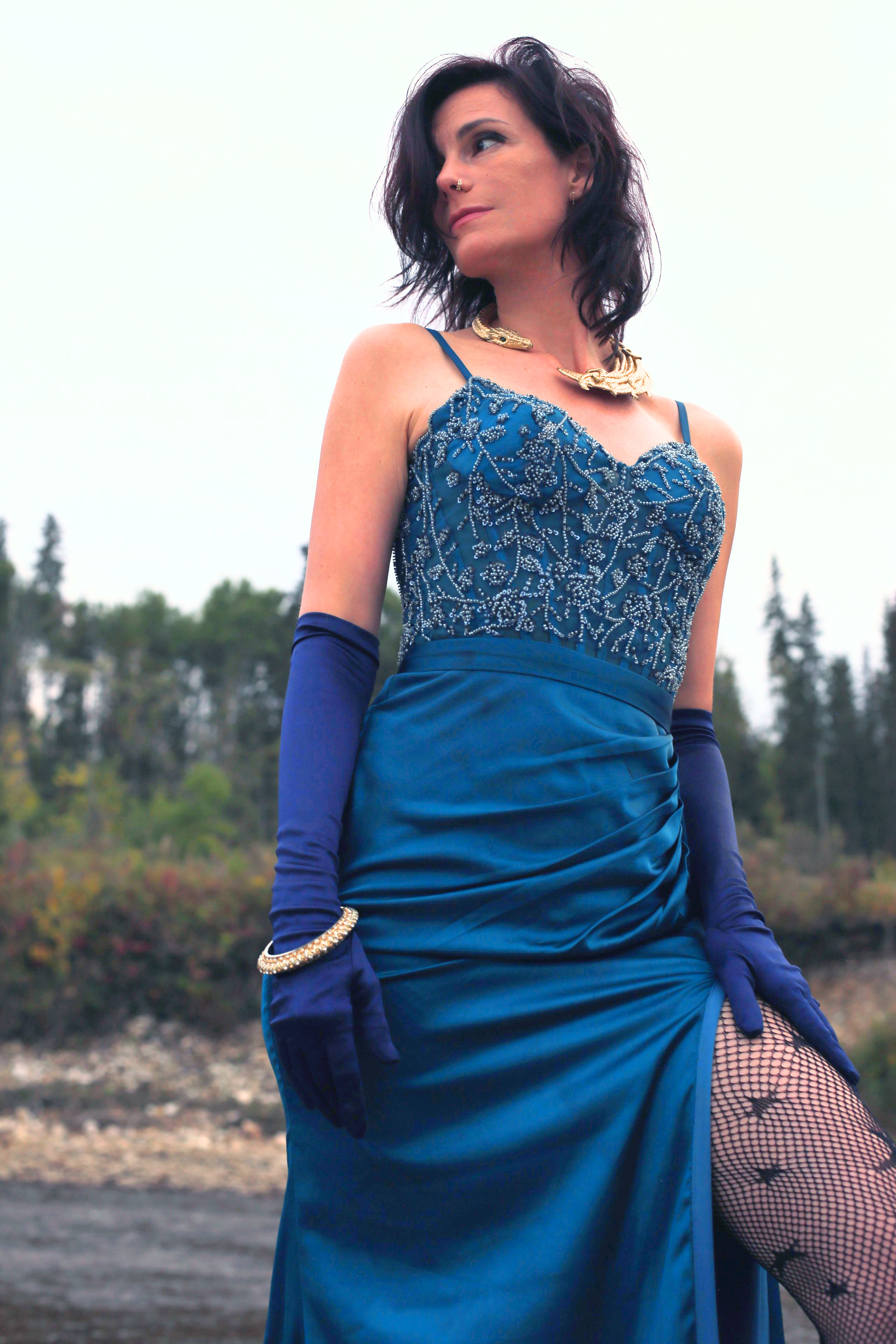 Portrait in a beaded teal gown and gold serpent collar