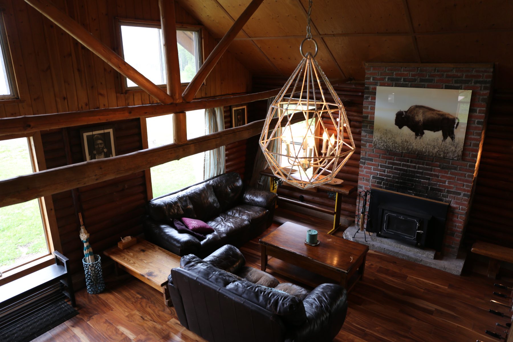The great room from the loft—leather sofas, the bison canvas and the woodstove