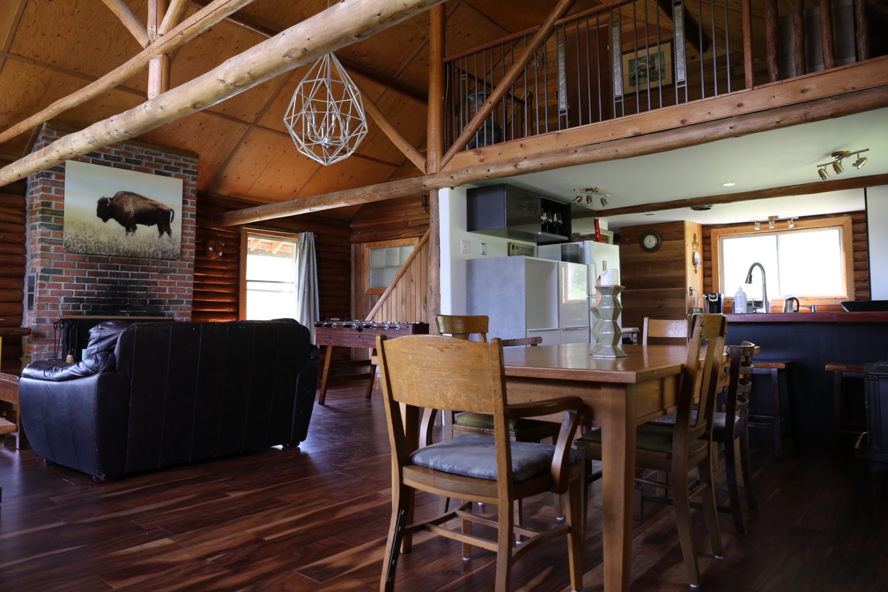 The great room looking across the dining table and foosball to the kitchen and loft