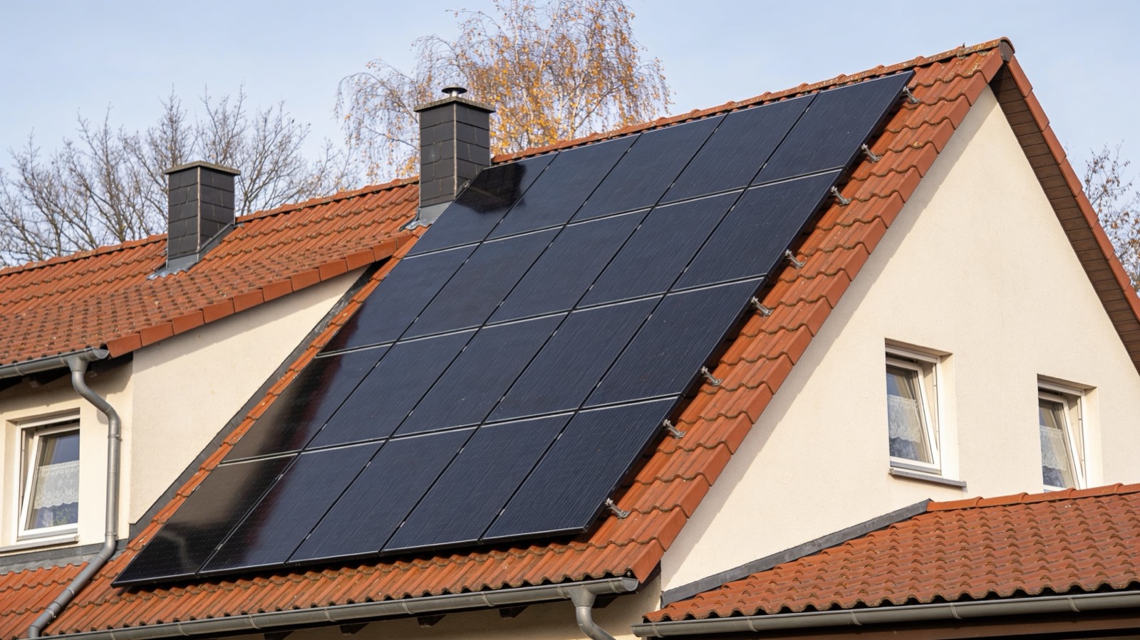 Solarmodule auf dem Ziegeldach eines Einfamilienhauses in Brandenburg im klaren Herbstlicht.