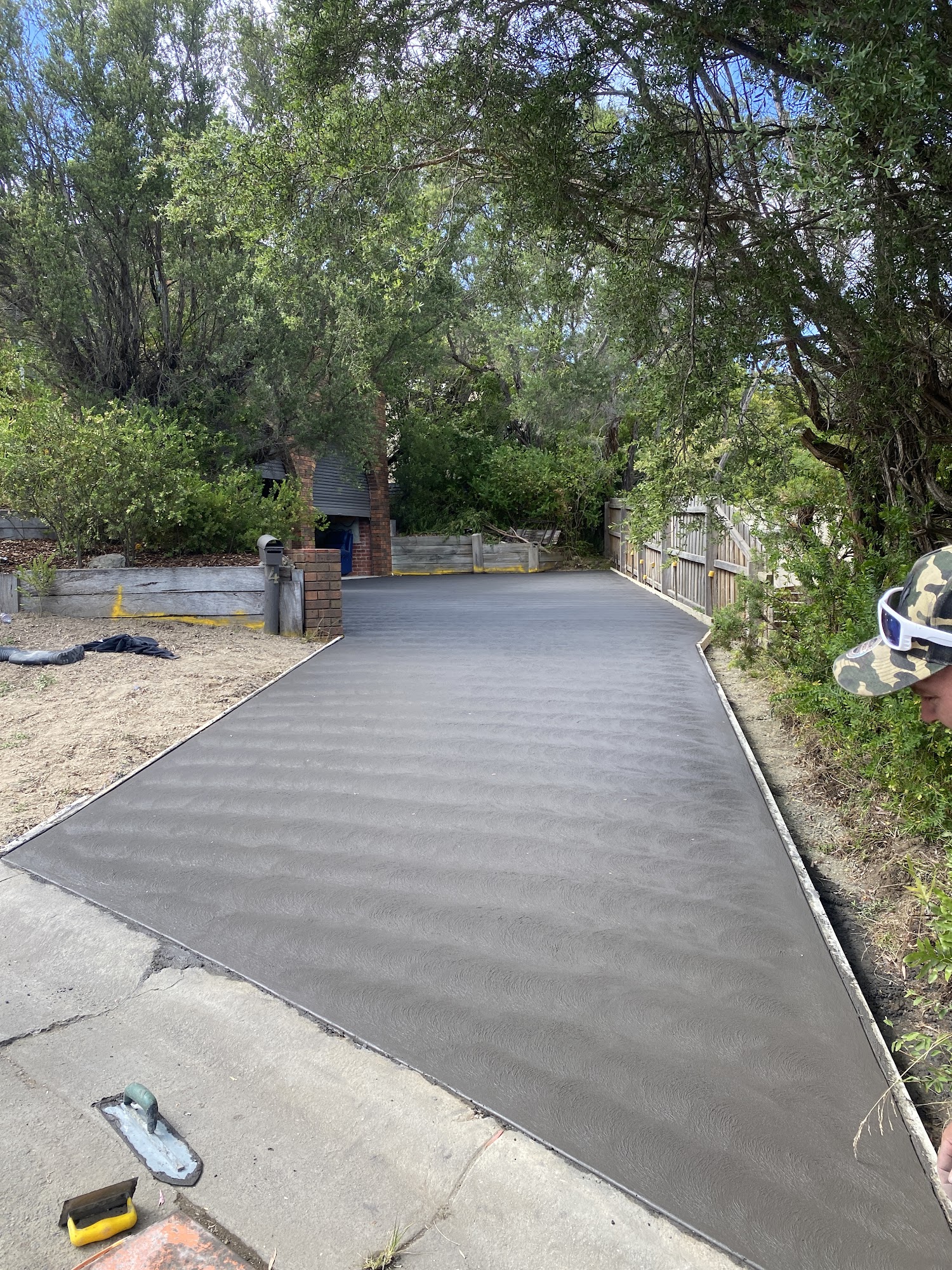 Freshly poured concrete driveway leading to a Melbourne home by Kalm Concrete