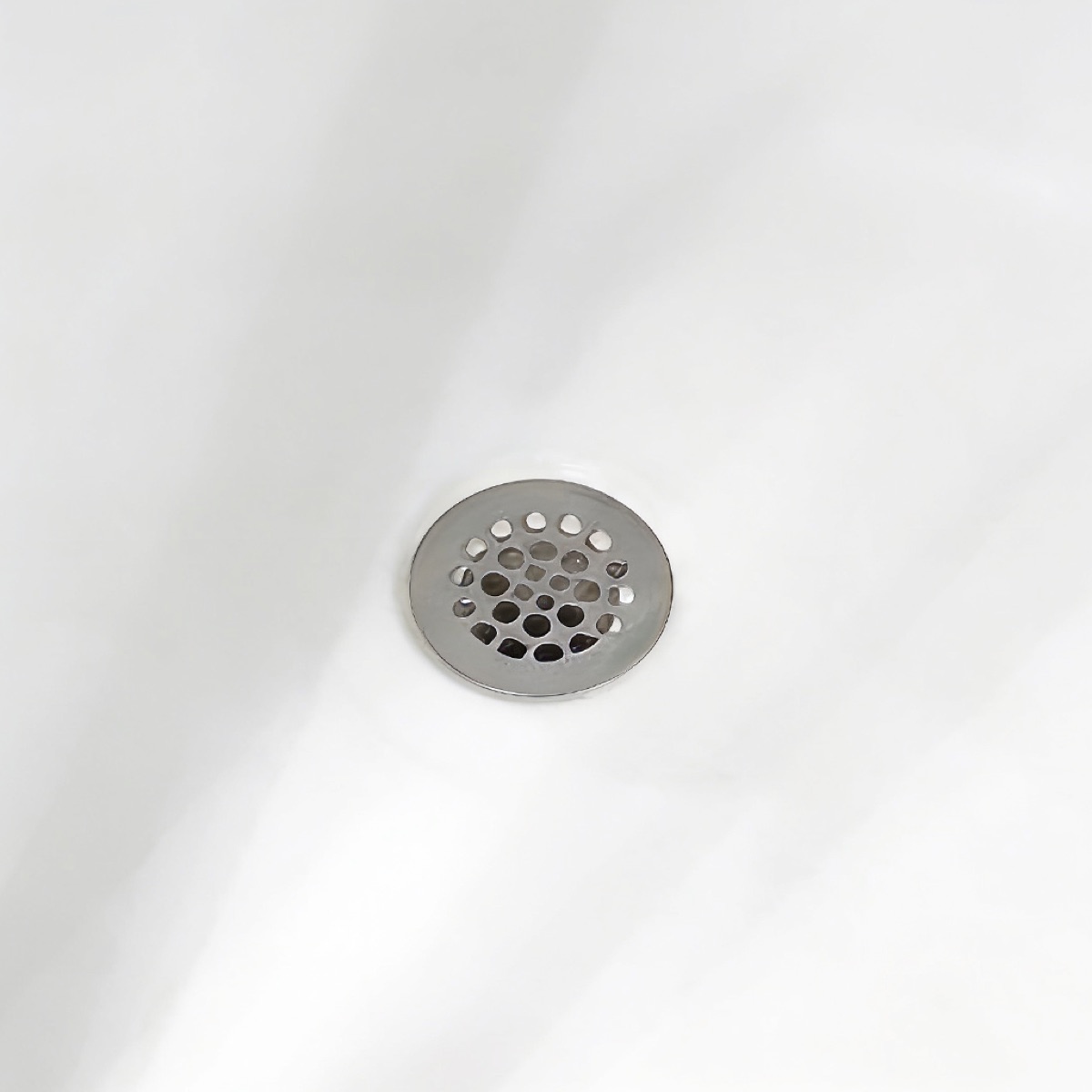 The same drain after refinishing: smooth, bright white surface