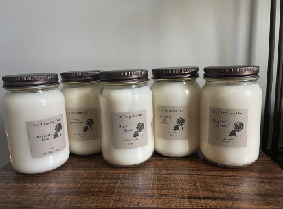 Hand-poured soy candle burning in a mason jar