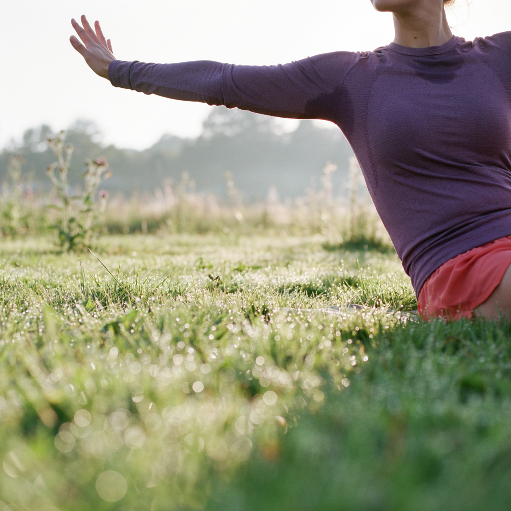 Yoga mat waiting on sunlit grass beneath tall pines at Long Leaf Park