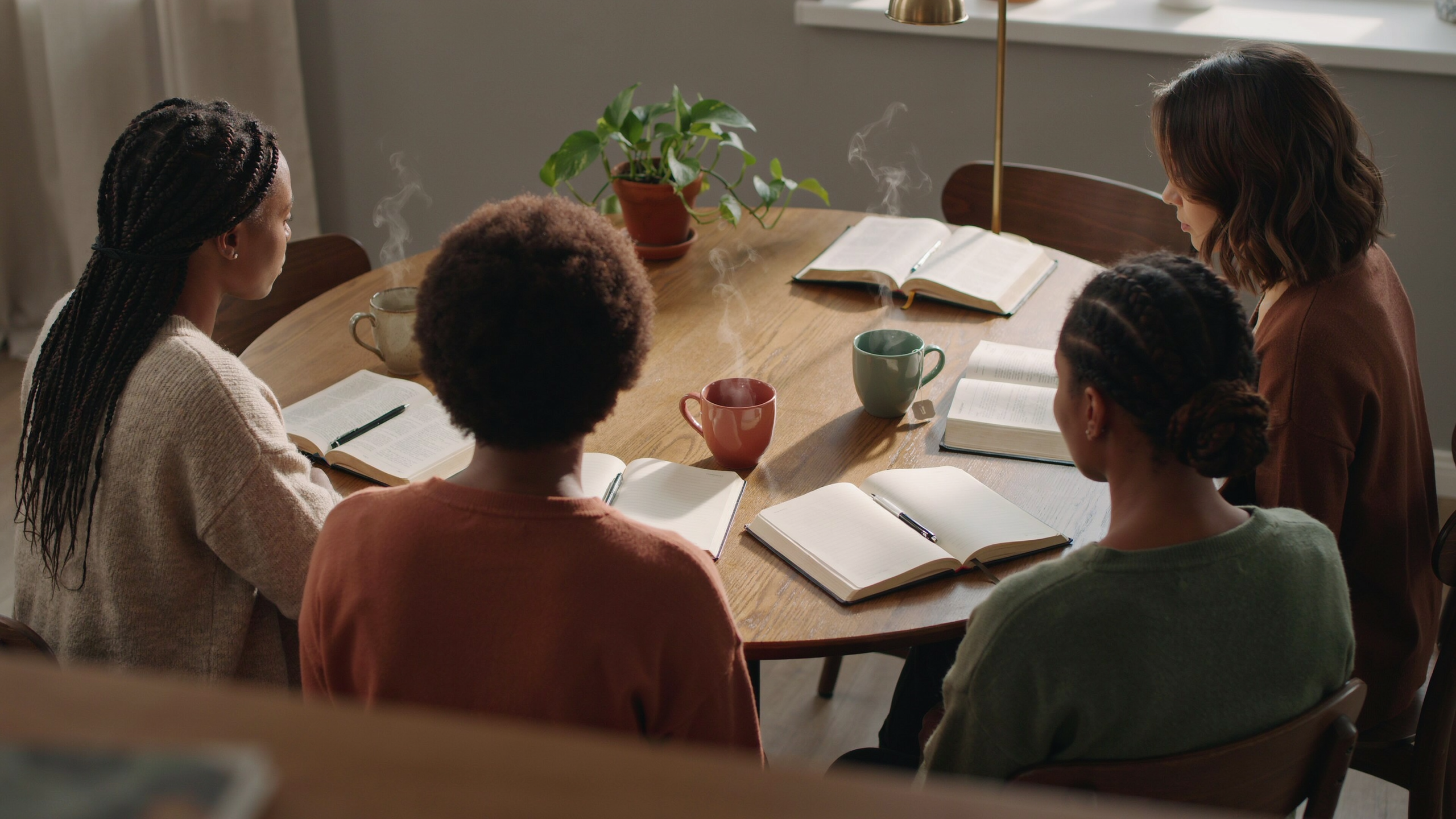 Women gathered around a table with open Bibles