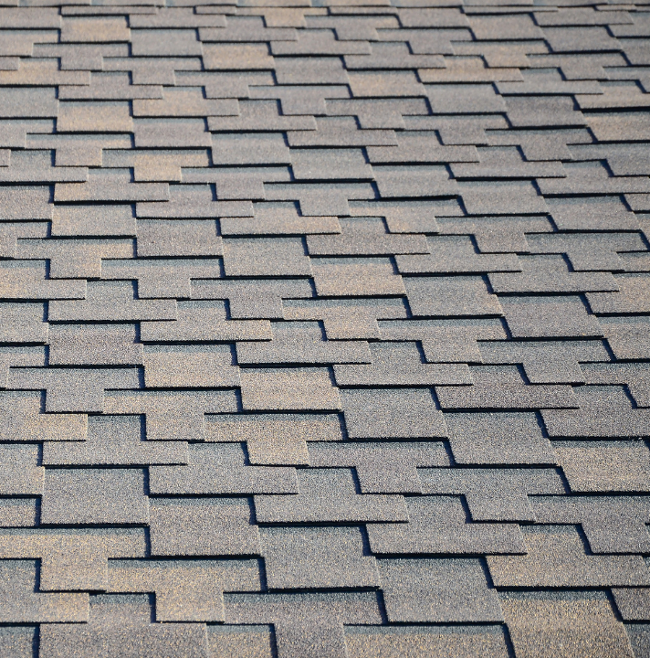 Roofing shingles in a textured pattern, showcasing quality materials used in residential roofing services by Sun Force Roofing.