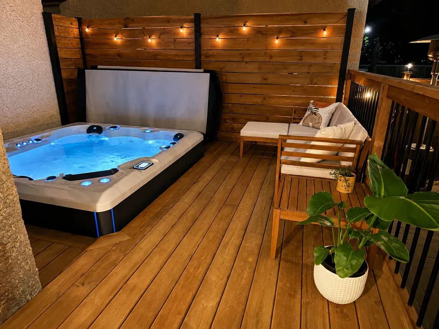 Illuminated hot tub in a finished private deck setting at night