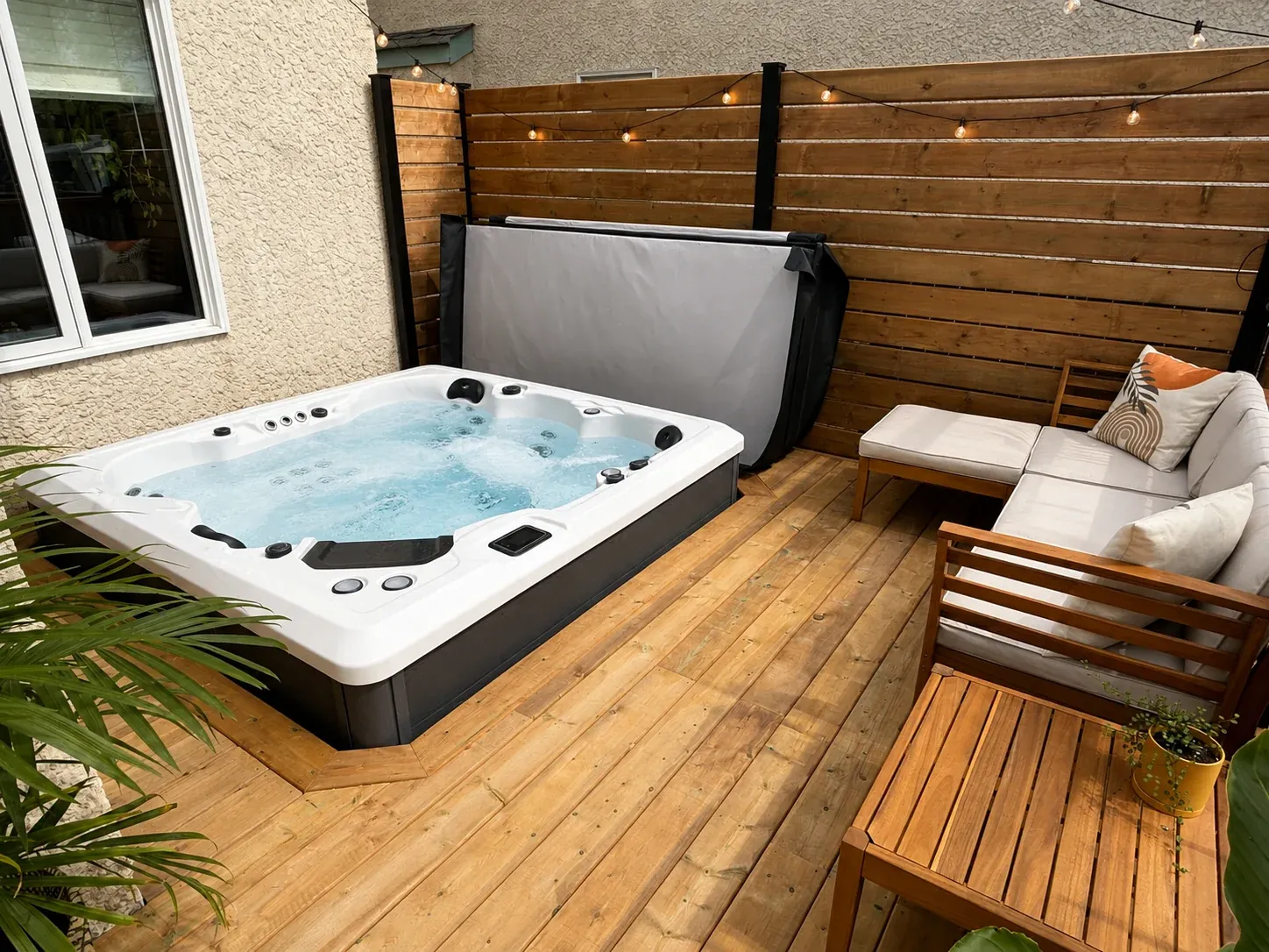 Finished hot tub in a private outdoor setting with lounge seating