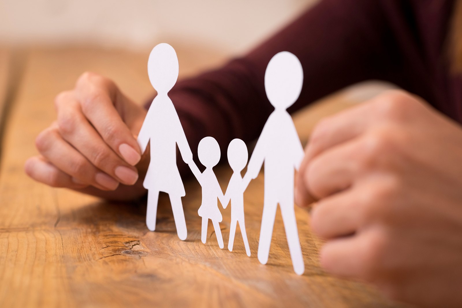 Parents' hands around a paper family — partnering with families at PCA
