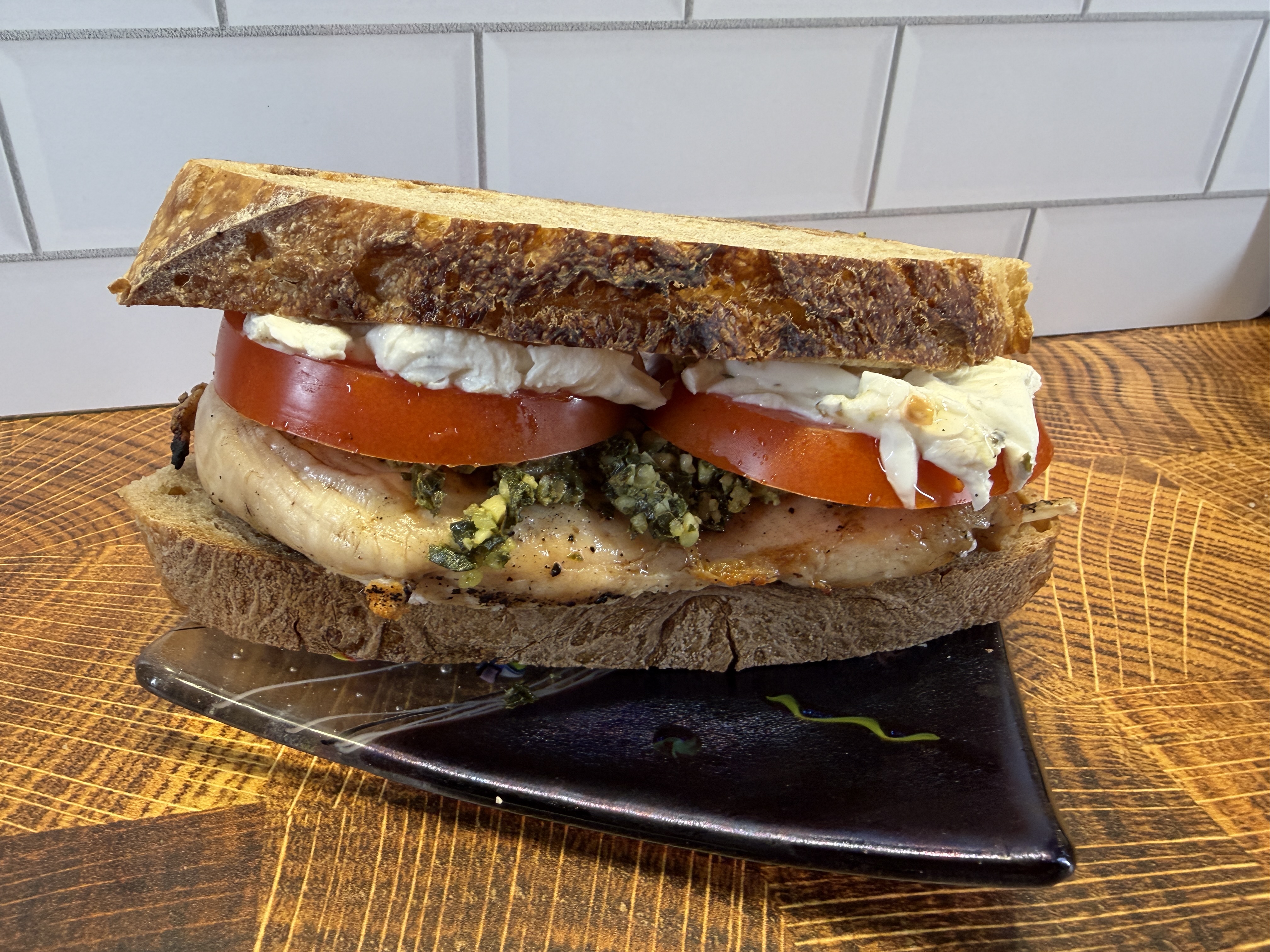 Grilled chicken sandwich on sourdough with pesto and tomato