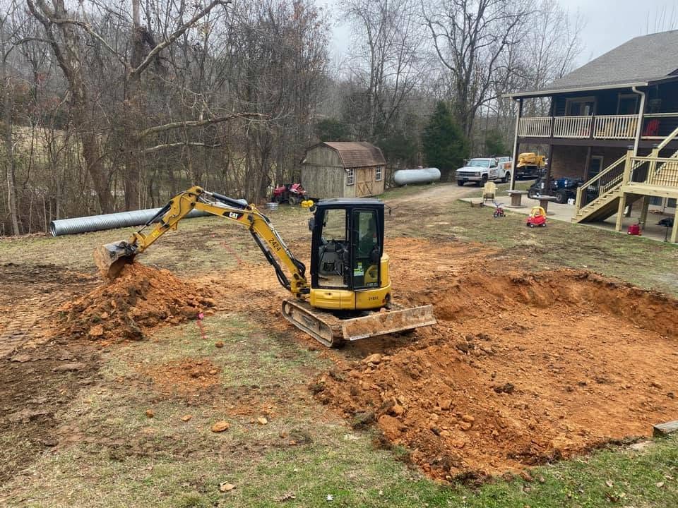 Blackburn Construction excavator installing drainage pipe near a Middle Tennessee home