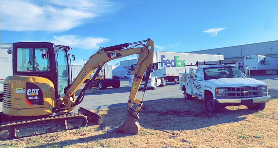 Blackburn Construction excavator and work truck staged for a commercial site work project