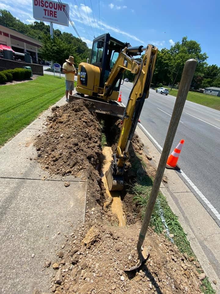 Commercial utility trenching near a roadside business with excavation equipment