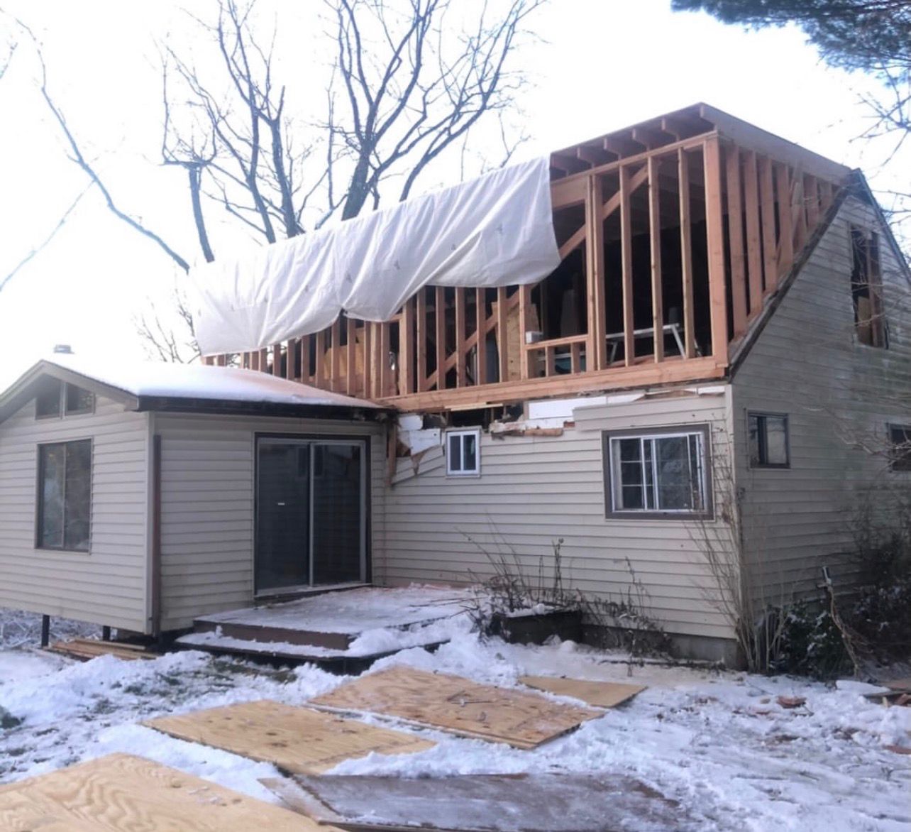 Second story addition construction in Westchester County showing new upper level framing being built on top of existing home structure in suburban neighborhood