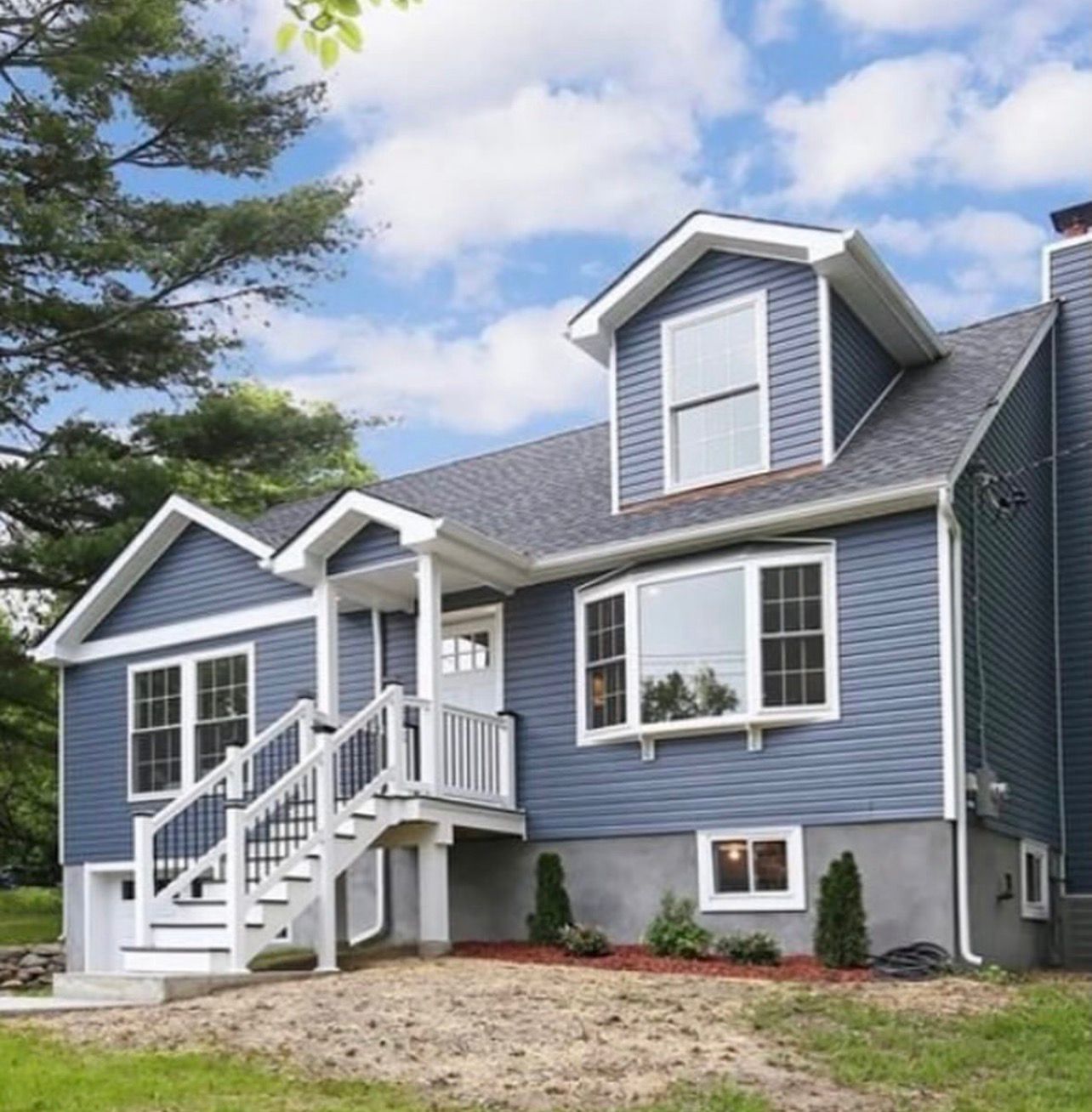 Completed second story addition on residential home in Westchester County showing finished upper level seamlessly integrated with original structure and full roof rebuild complete